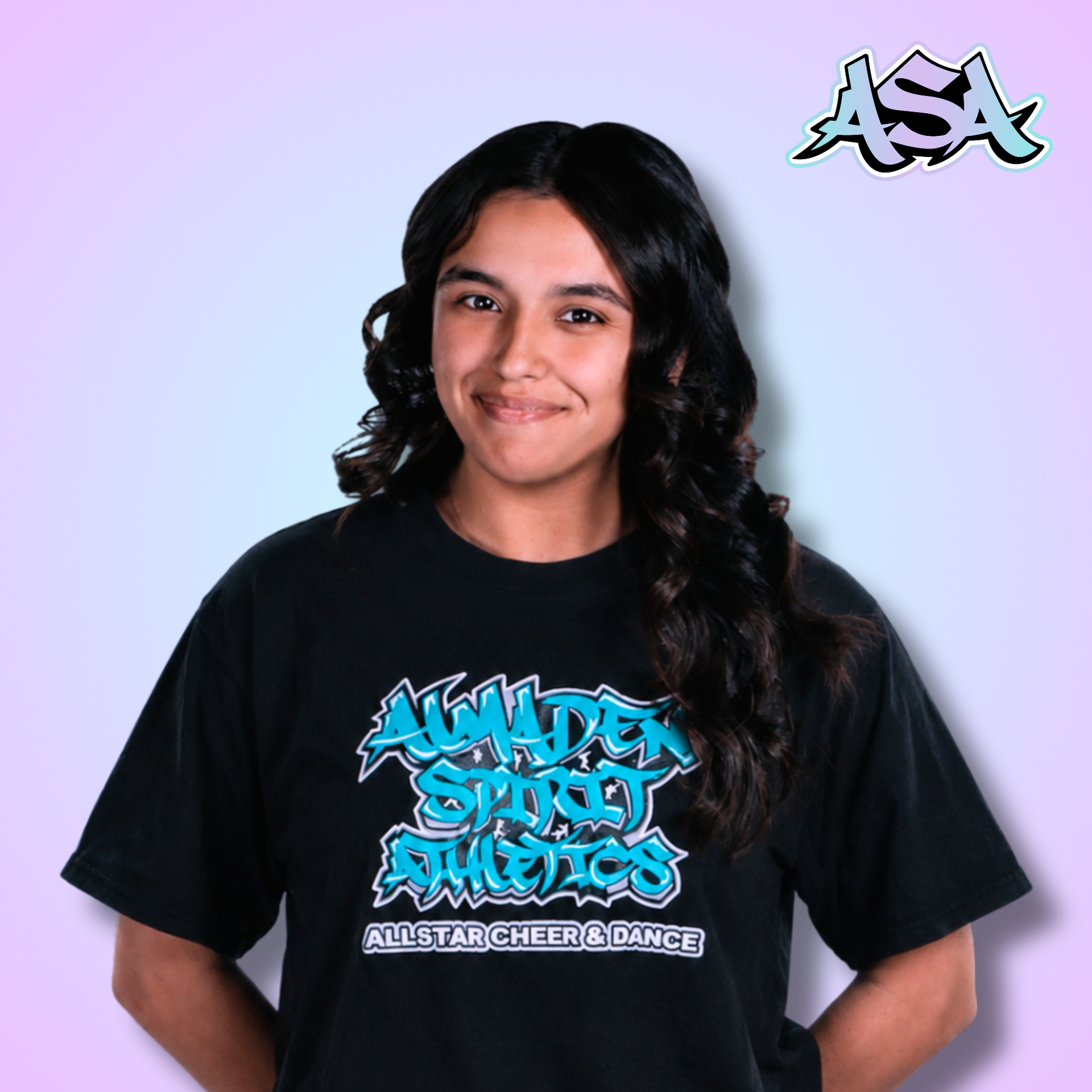 A woman wearing a black t-shirt with graffiti on it is smiling.