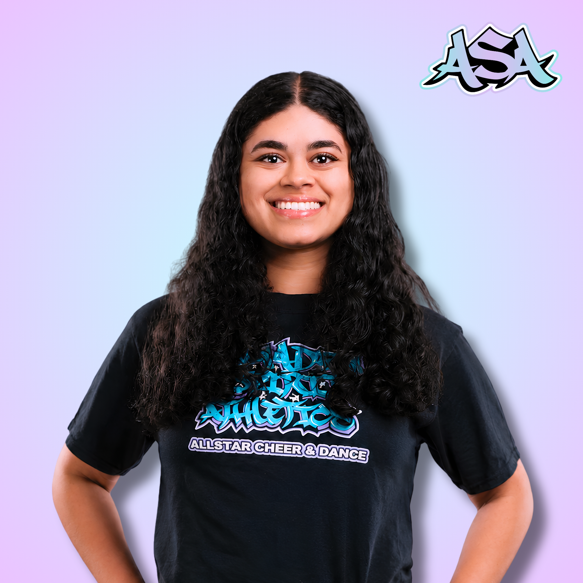 A young woman wearing a black t-shirt with graffiti on it is smiling.