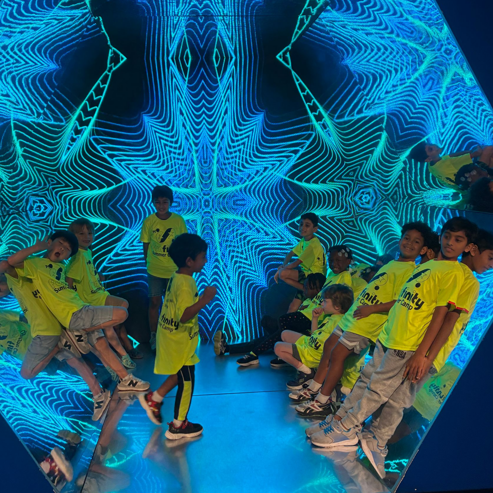 People seated on both sides of a neon blue star-patterned stage tunnel