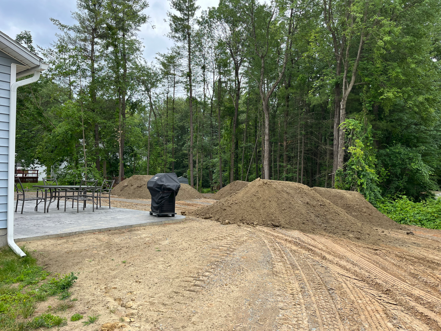A dump truck unloads sand at a construction site