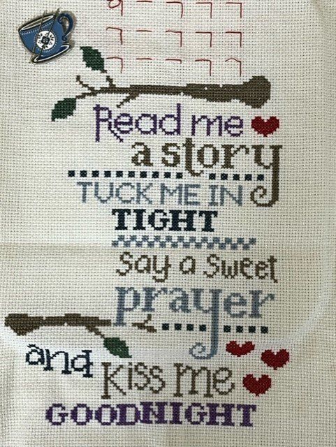 A cross-stitch sampler featuring the text 