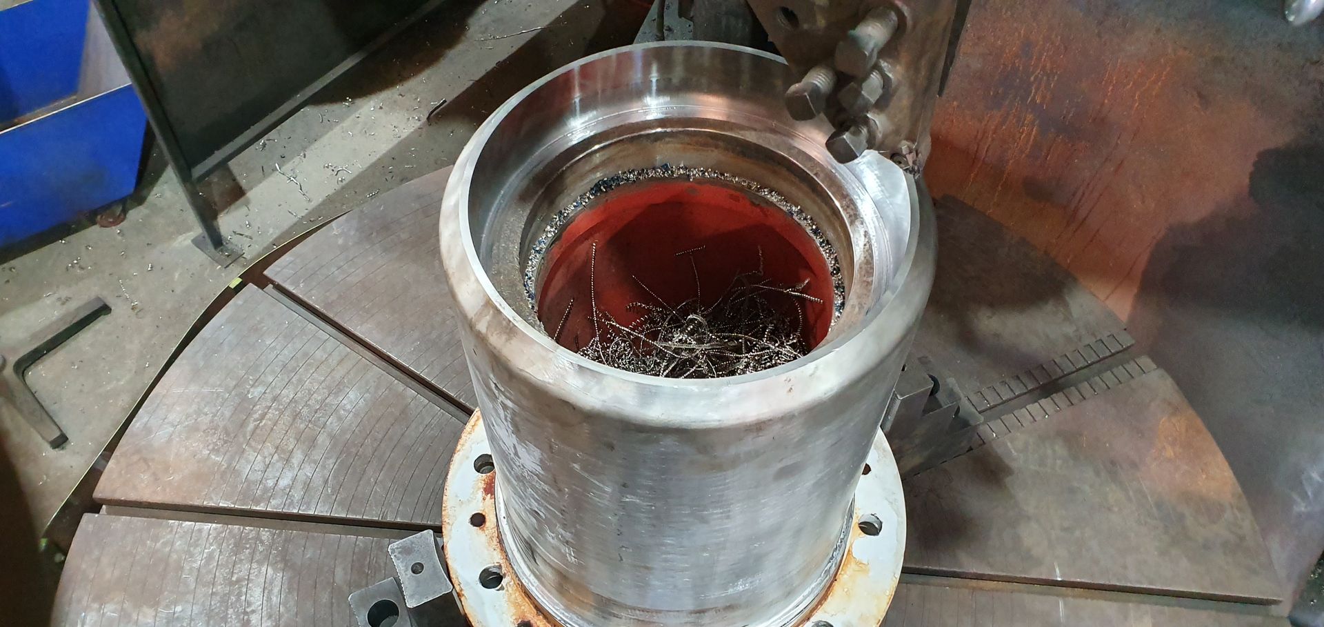 A metal cylinder filled with red liquid is sitting on a table.