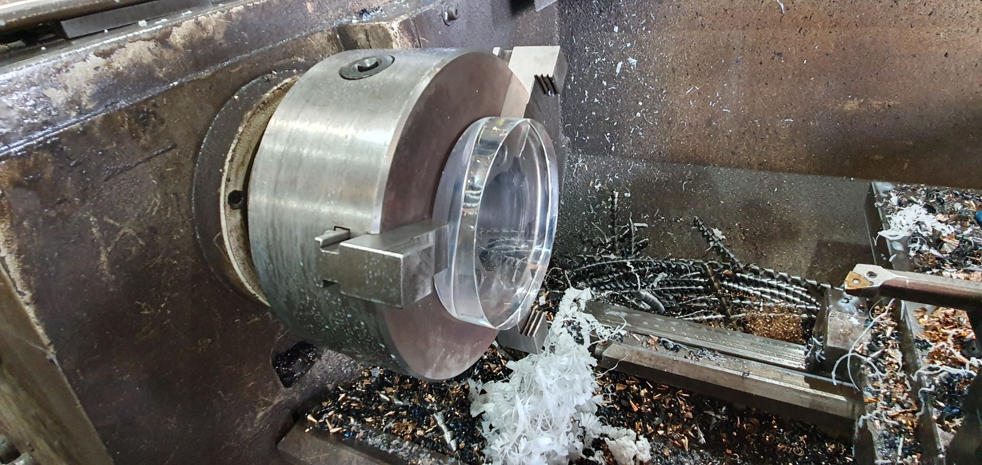 A machine is cutting a piece of metal on a lathe.