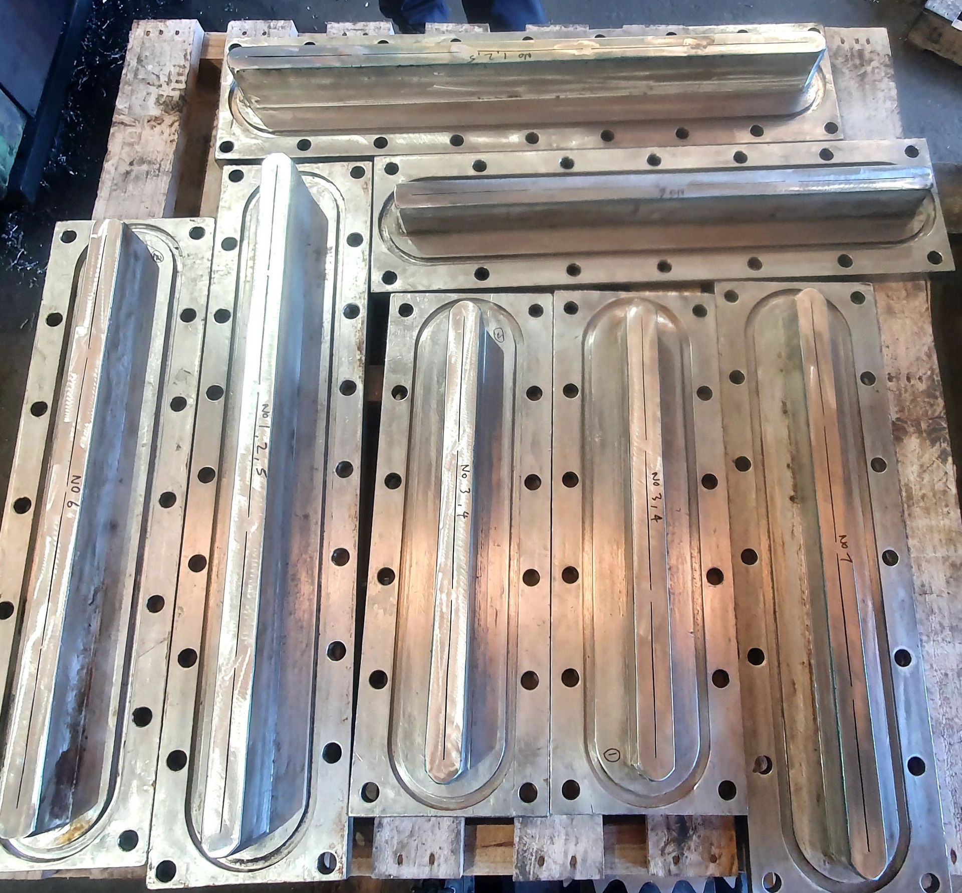 A bunch of metal pieces sitting on top of a wooden pallet