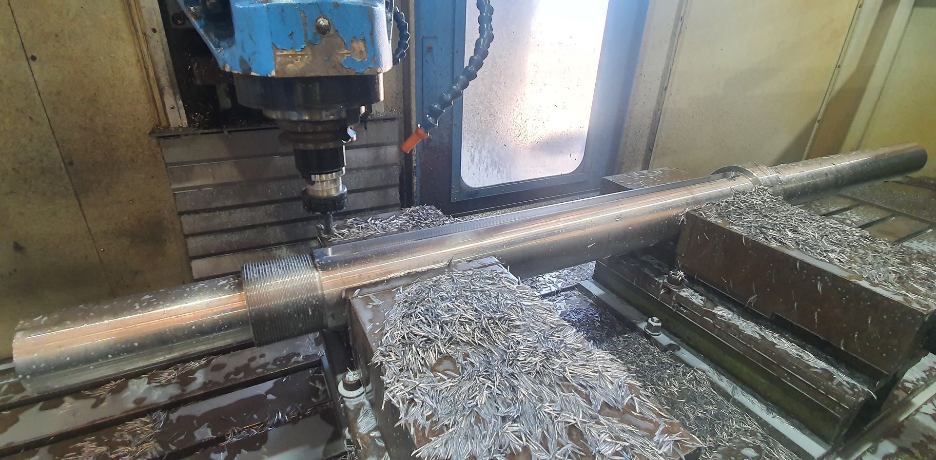 A machine is cutting a piece of metal in a factory.