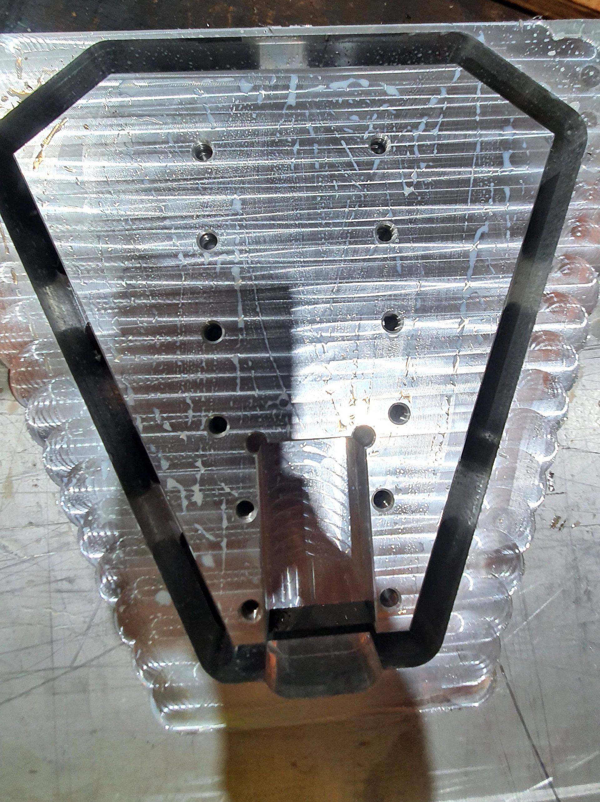 A piece of metal with holes in it is sitting on a table.