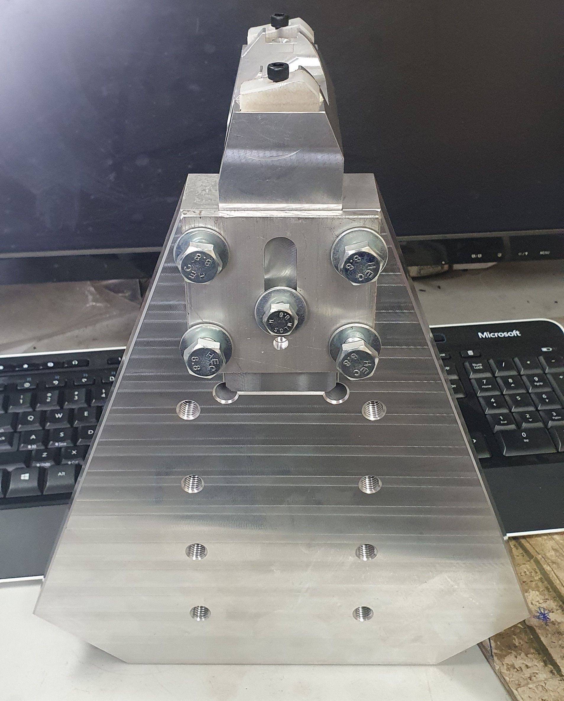 A metal object is sitting on a table next to a computer keyboard.