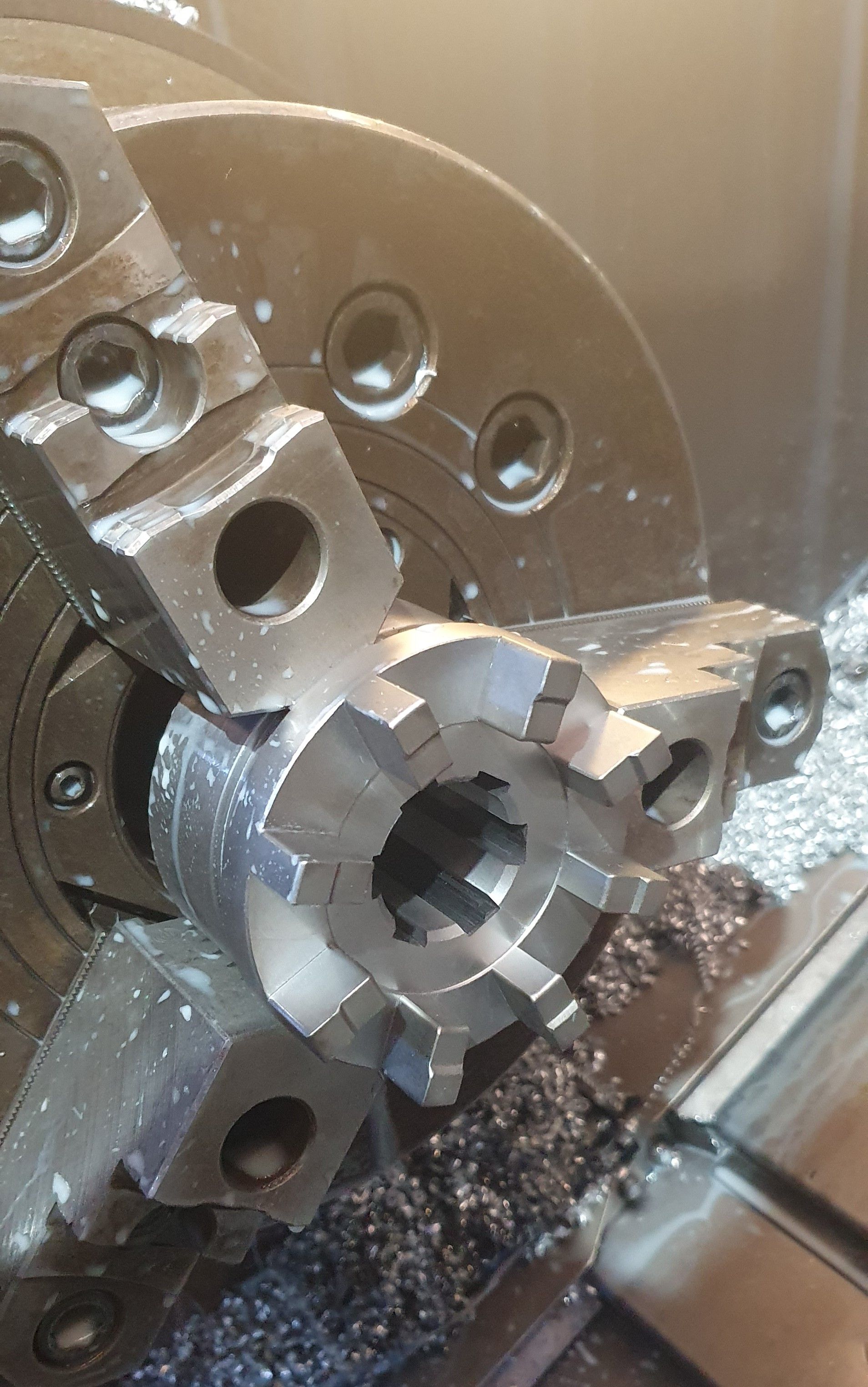 A machine is cutting a piece of metal on a lathe.