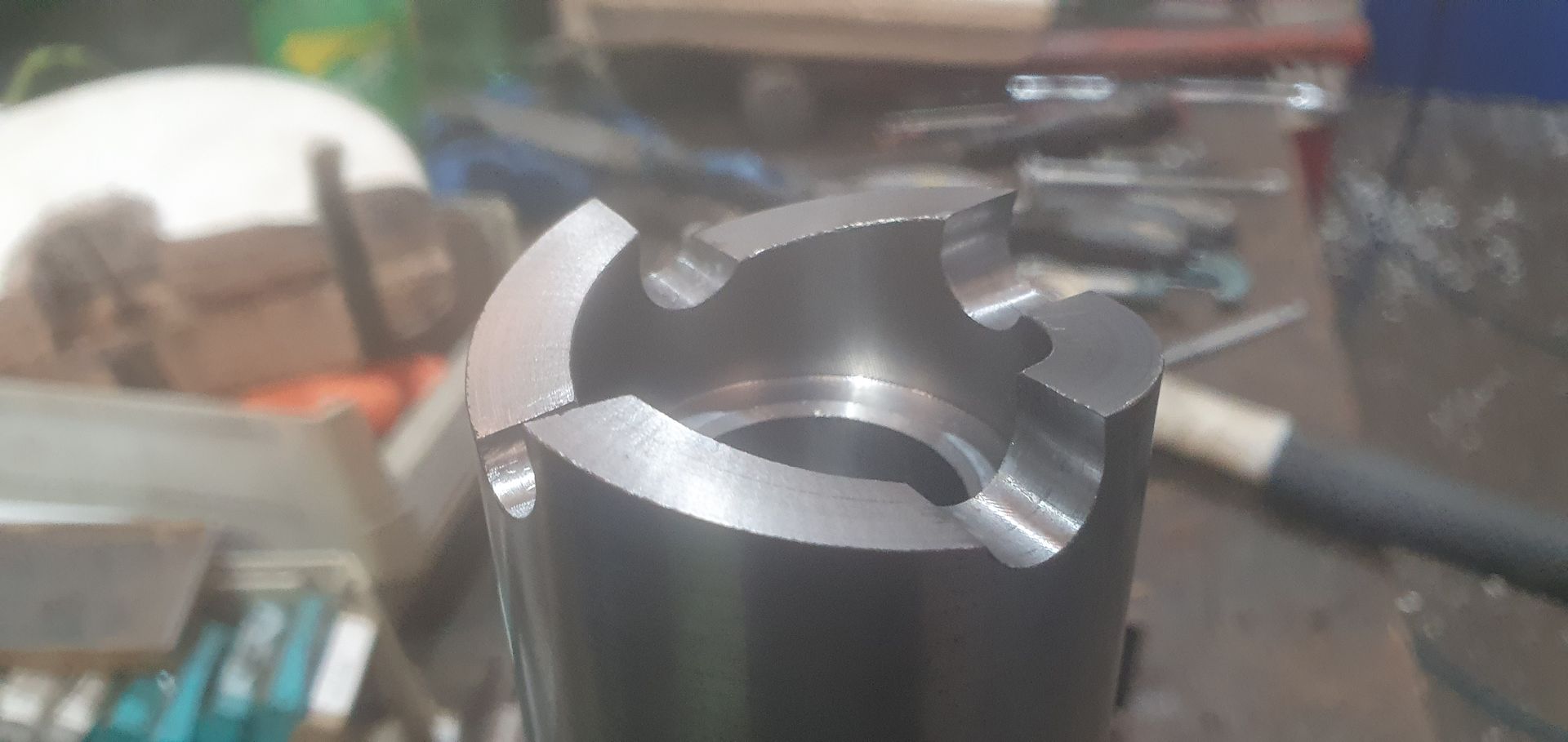 A close up of a metal object on a table with tools.