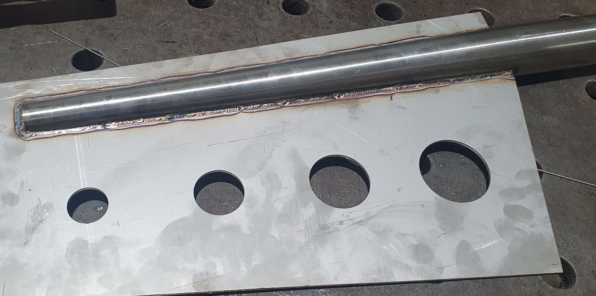 A piece of metal with holes in it is sitting on a table.