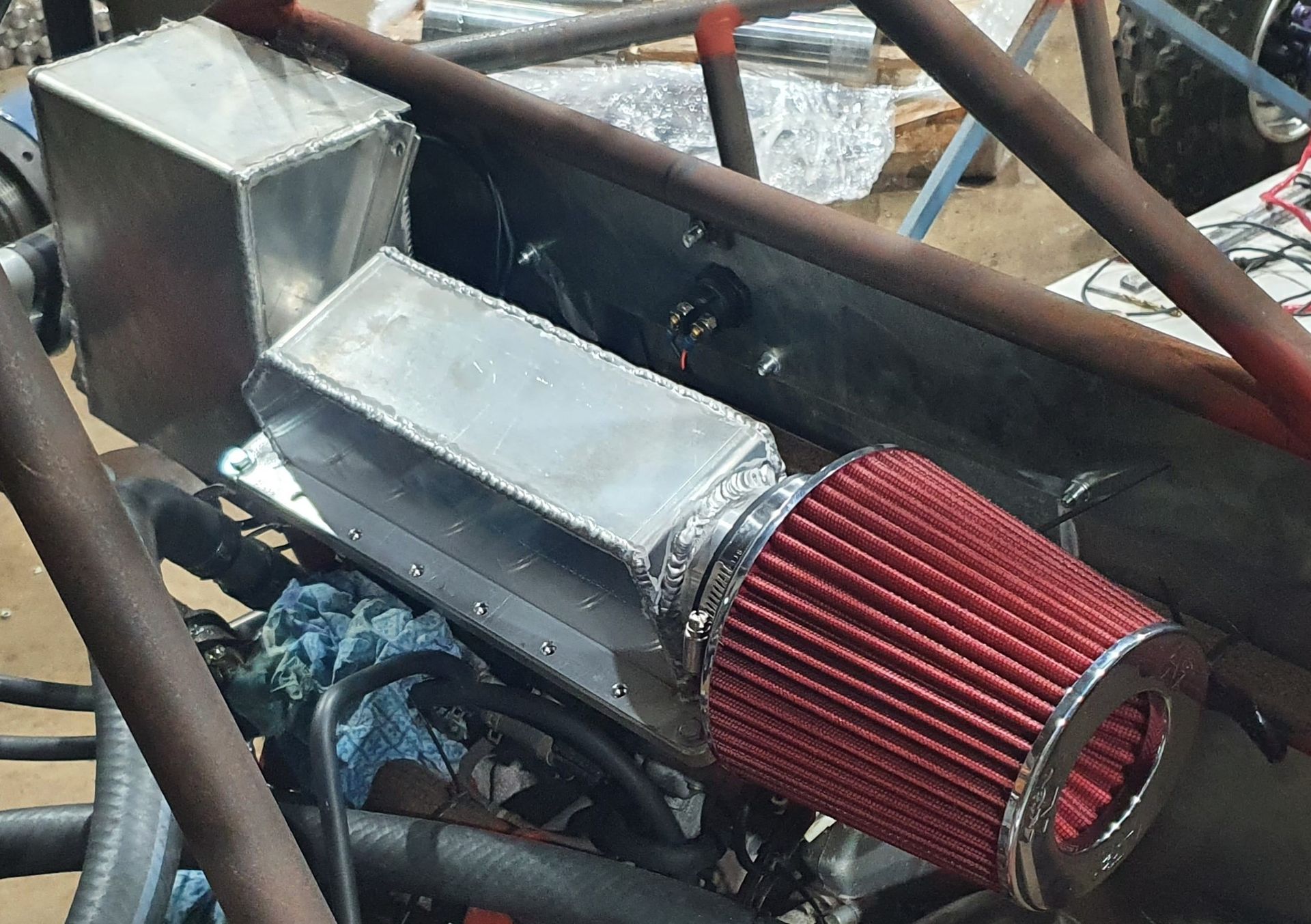 A close up of a red air filter on a car engine
