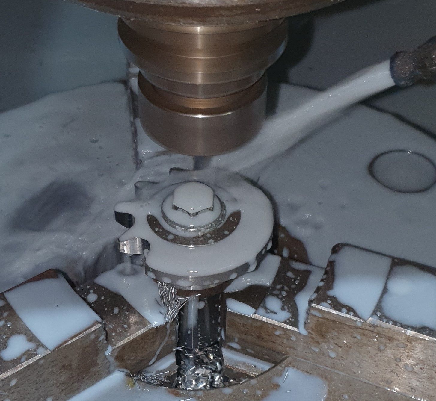 A drill bit is being used to cut a piece of metal