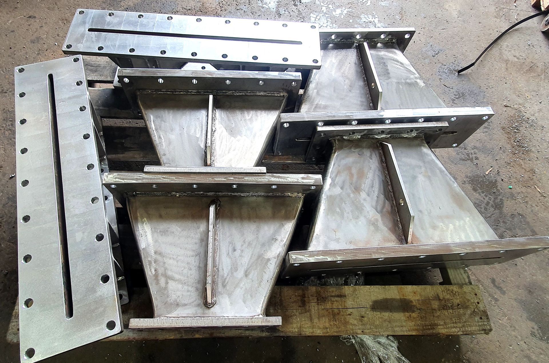 A bunch of metal pieces are stacked on top of each other on a wooden pallet