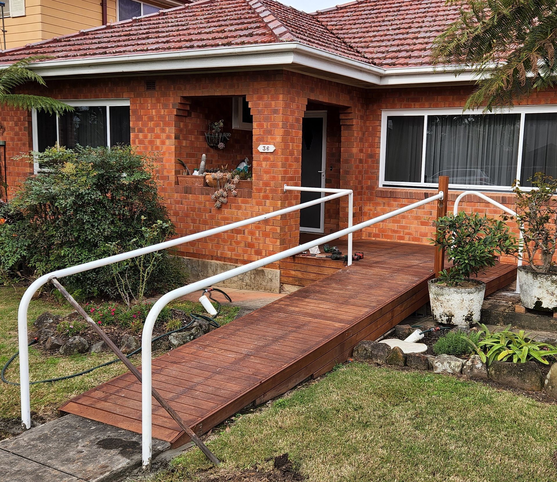 A wooden ramp is leading to the front of a brick house.