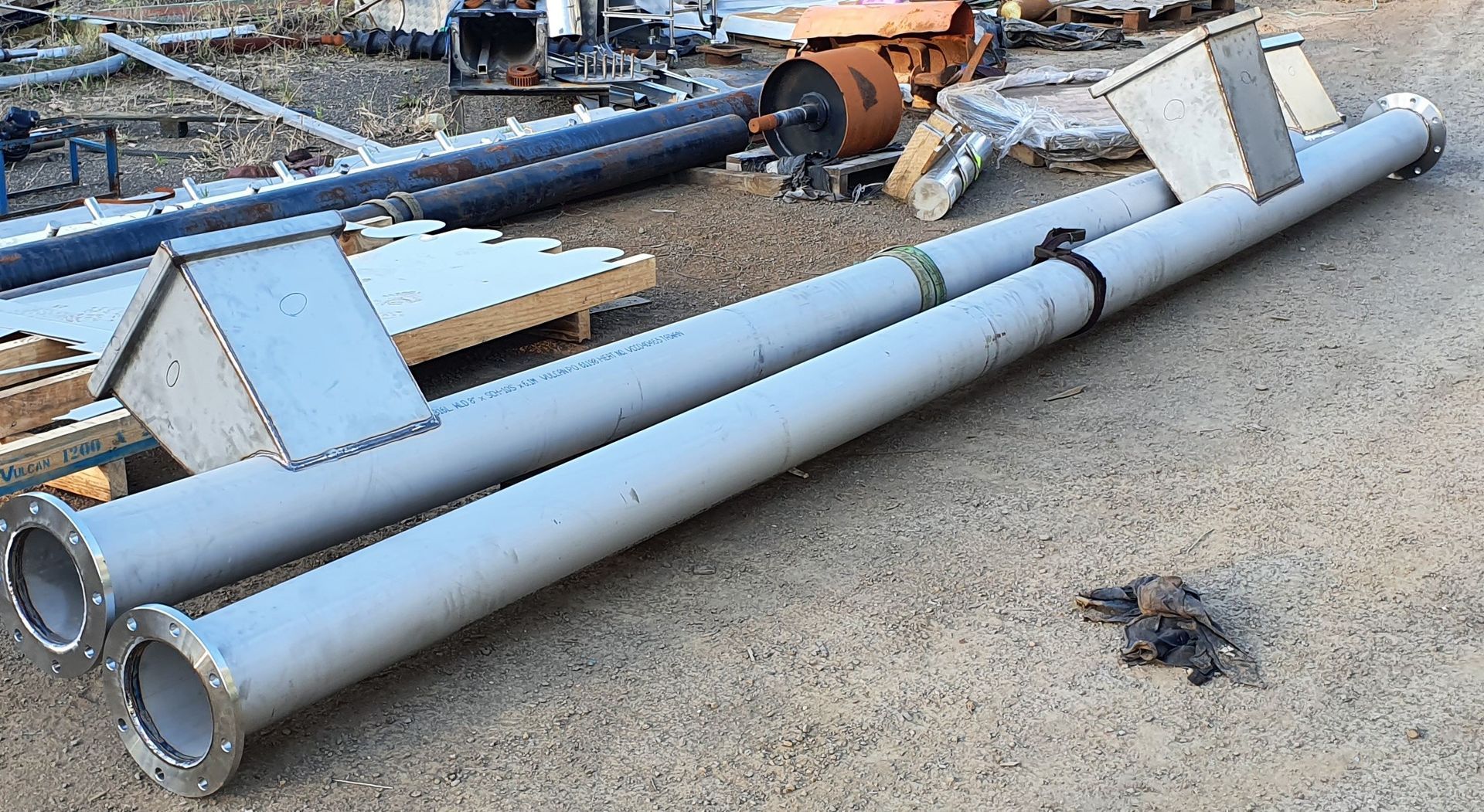 A bunch of metal pipes are laying on the ground