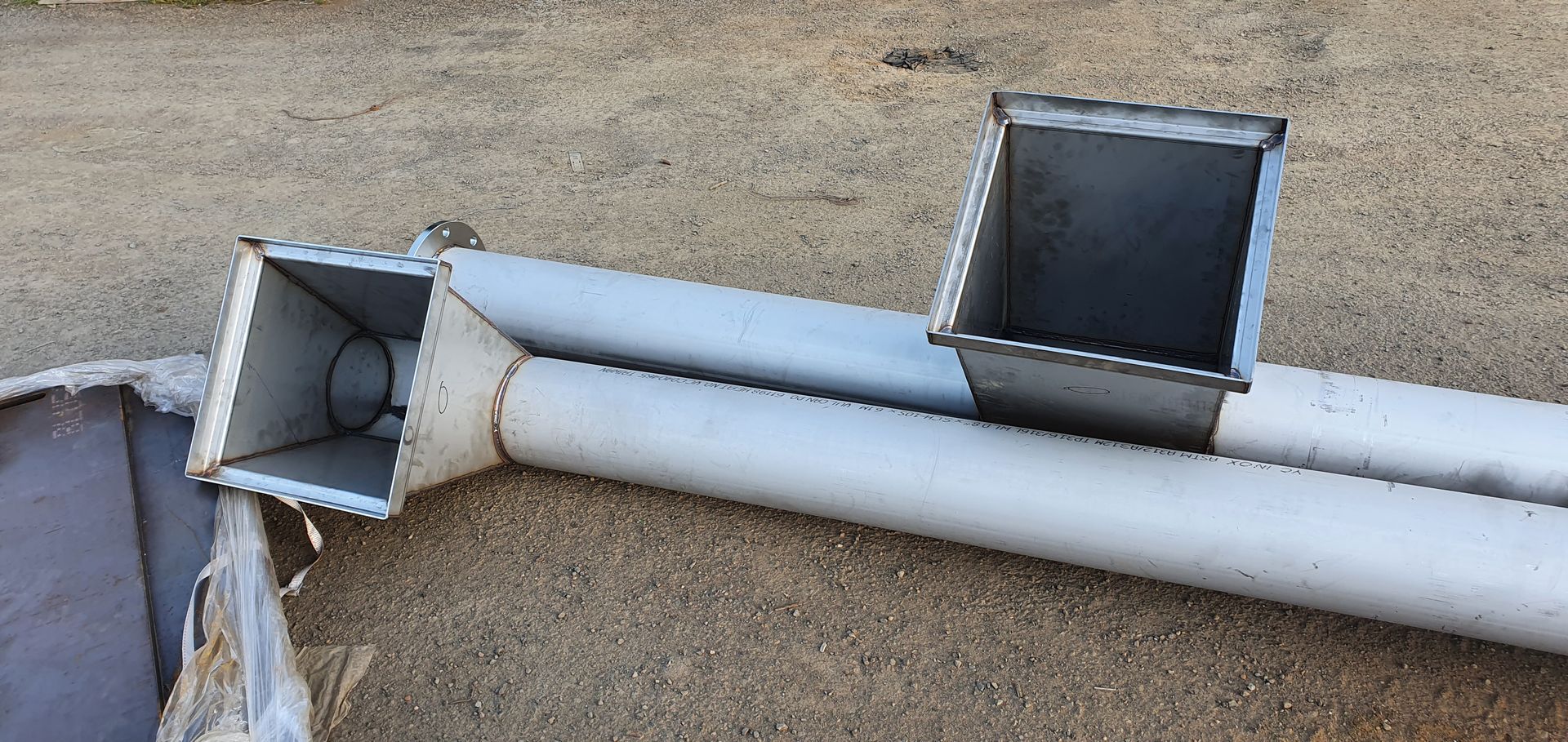 A couple of metal pipes are laying on the ground.