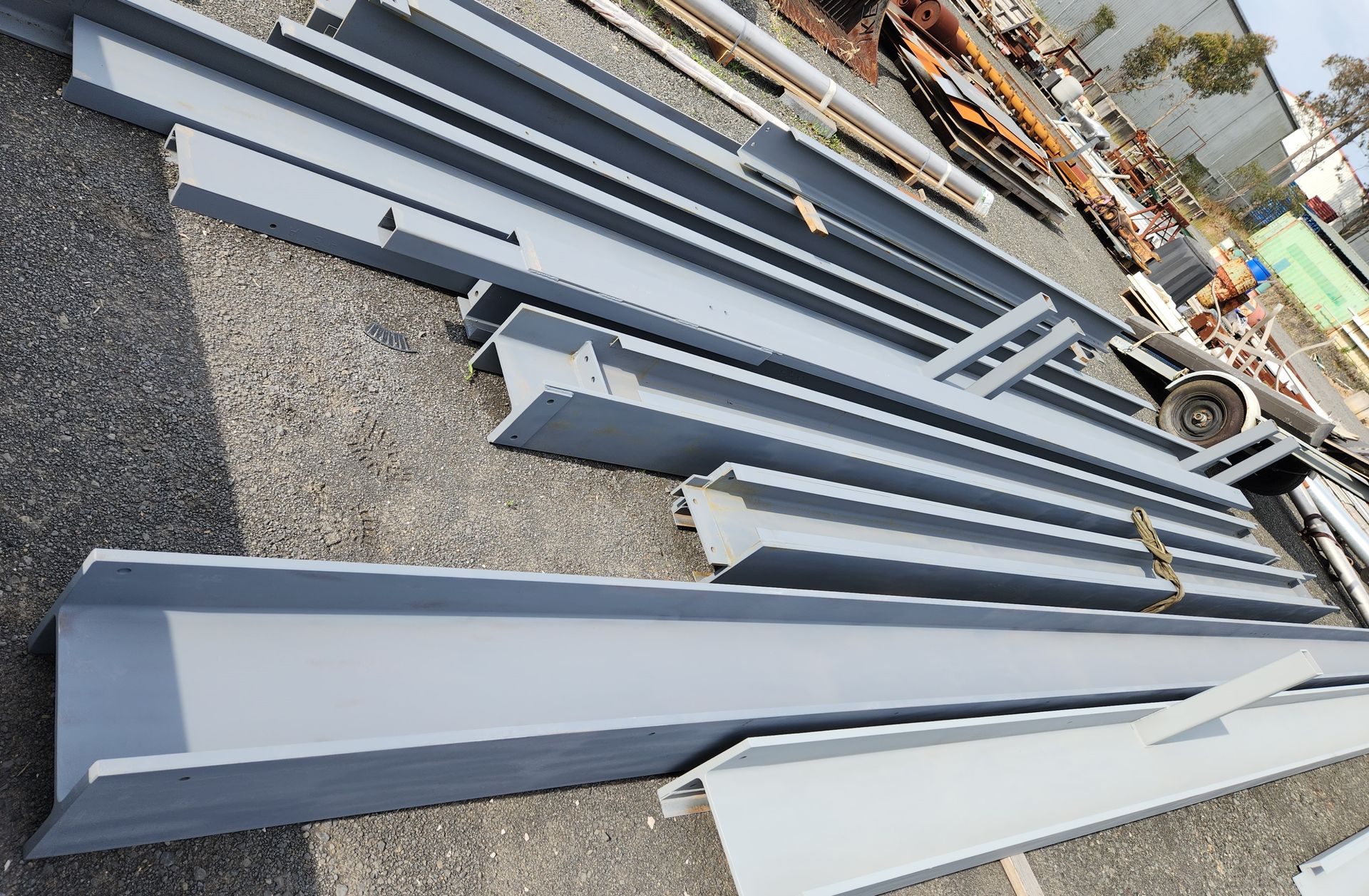A bunch of metal beams are stacked on top of each other on the ground.