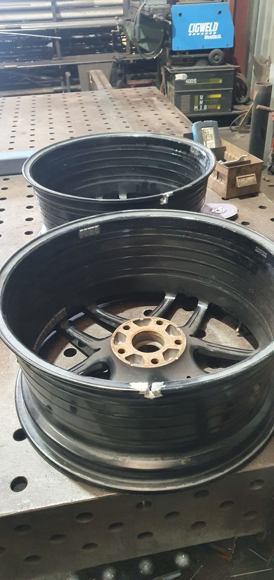 Two black wheels are sitting on top of a metal table.