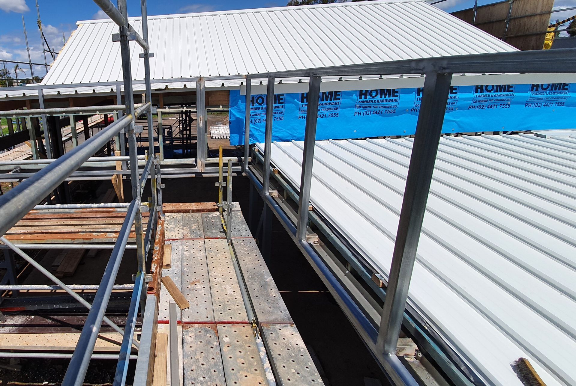 A building under construction with scaffolding and a white roof