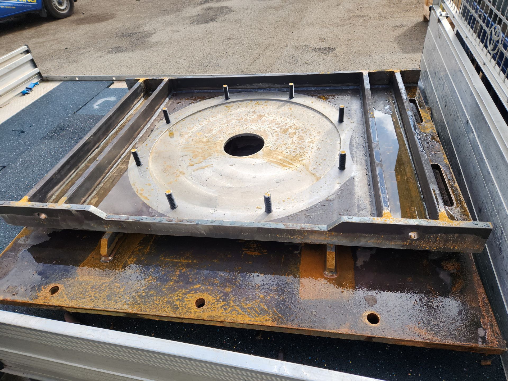 A piece of metal with a hole in the middle is sitting on the back of a truck.