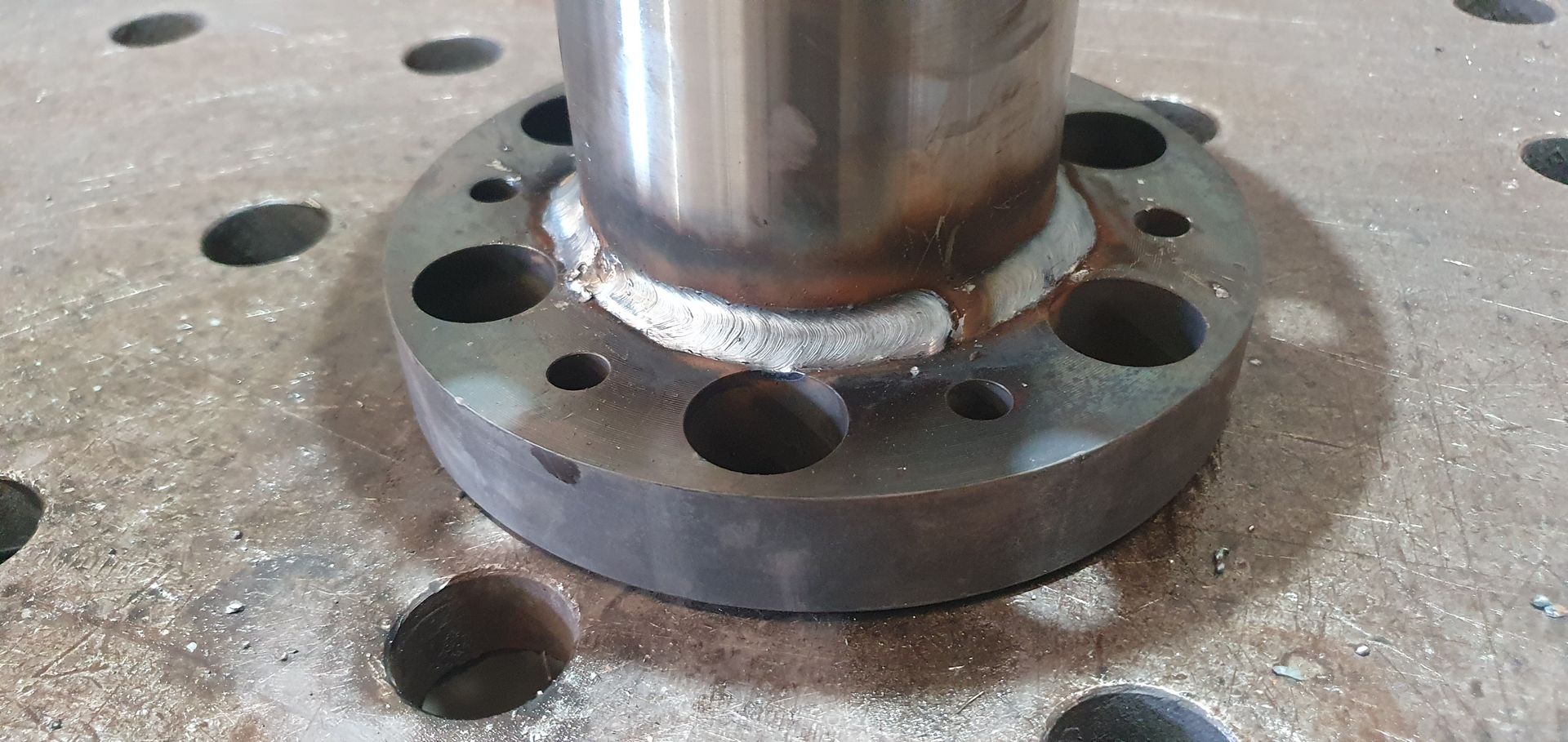 A close up of a metal piece with holes in it.