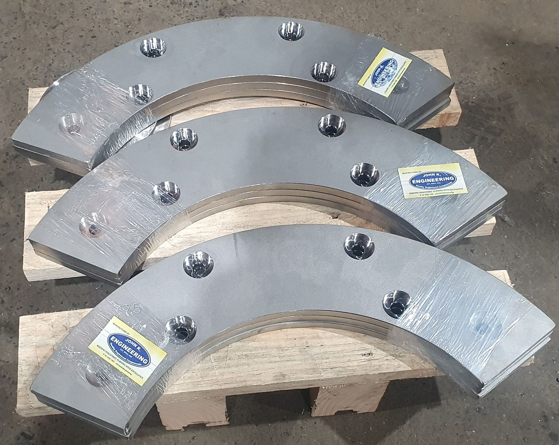 Three pieces of metal are sitting on a wooden pallet
