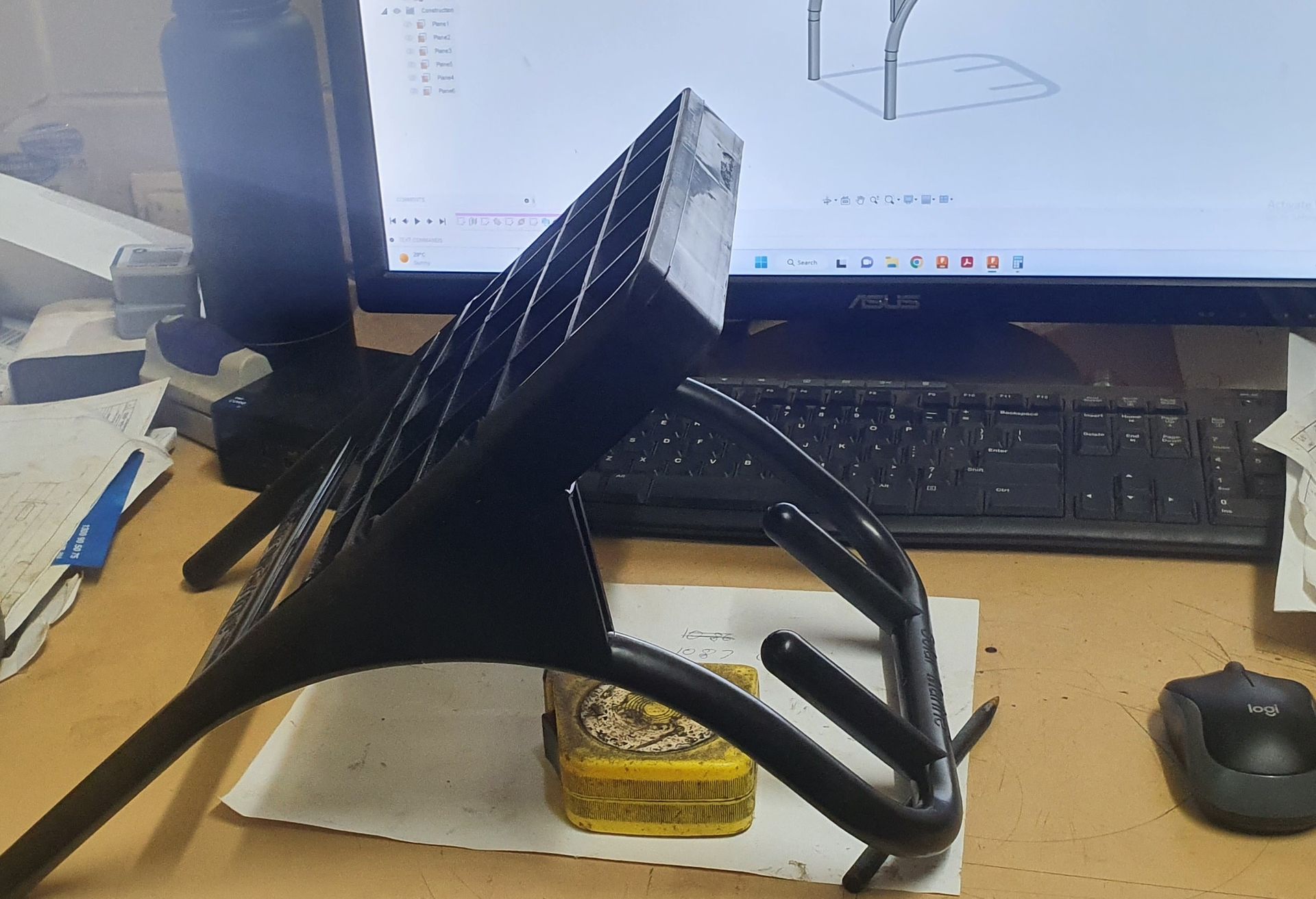 A 3d model of a hand is sitting on a desk in front of a computer monitor