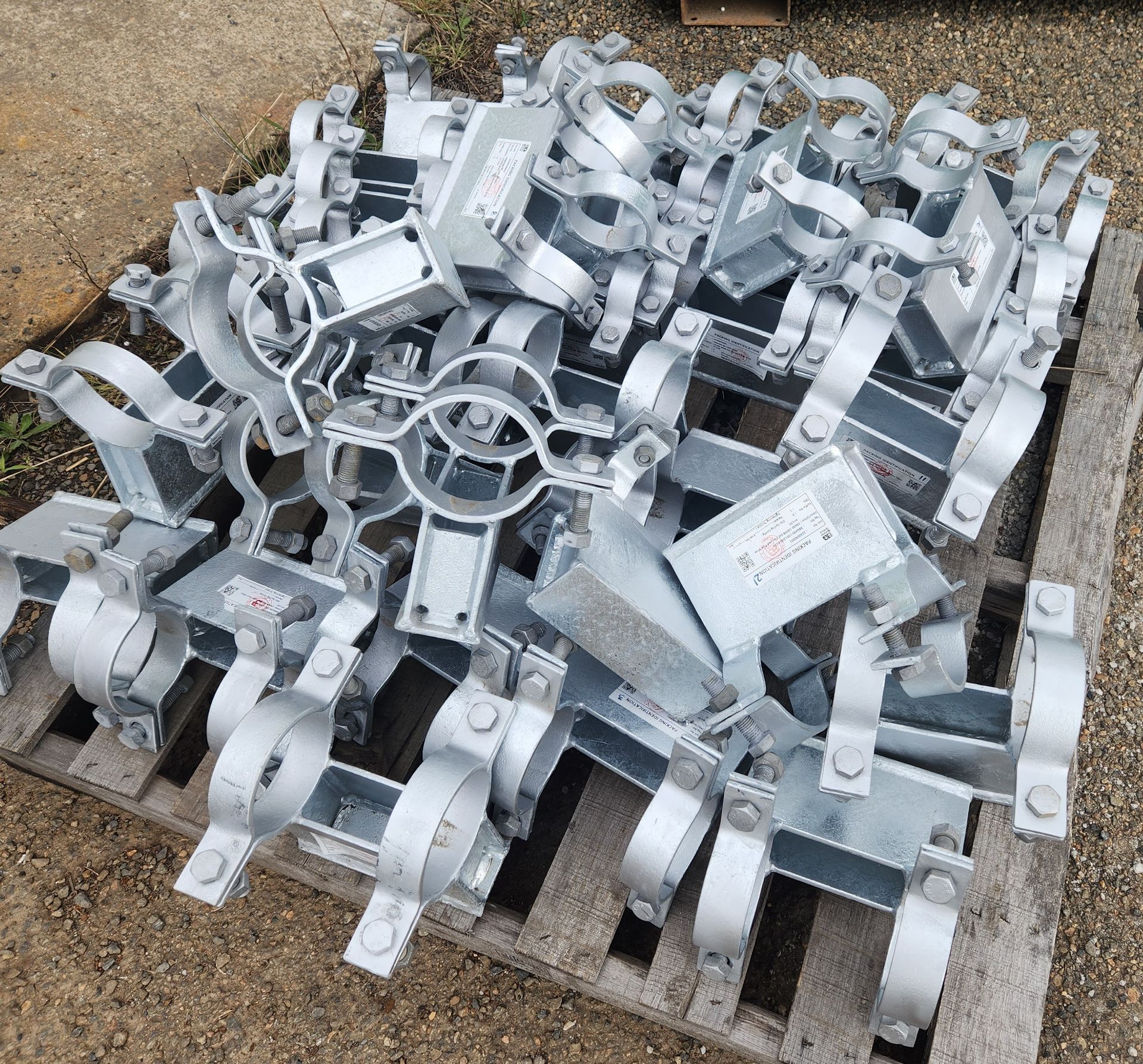 A pile of metal pipe clamps on a wooden pallet