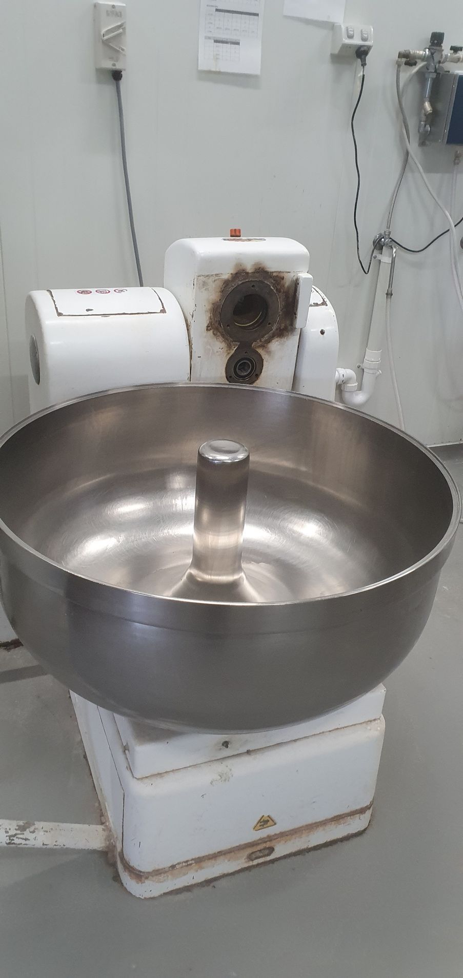 A large stainless steel bowl is sitting on top of a white box.