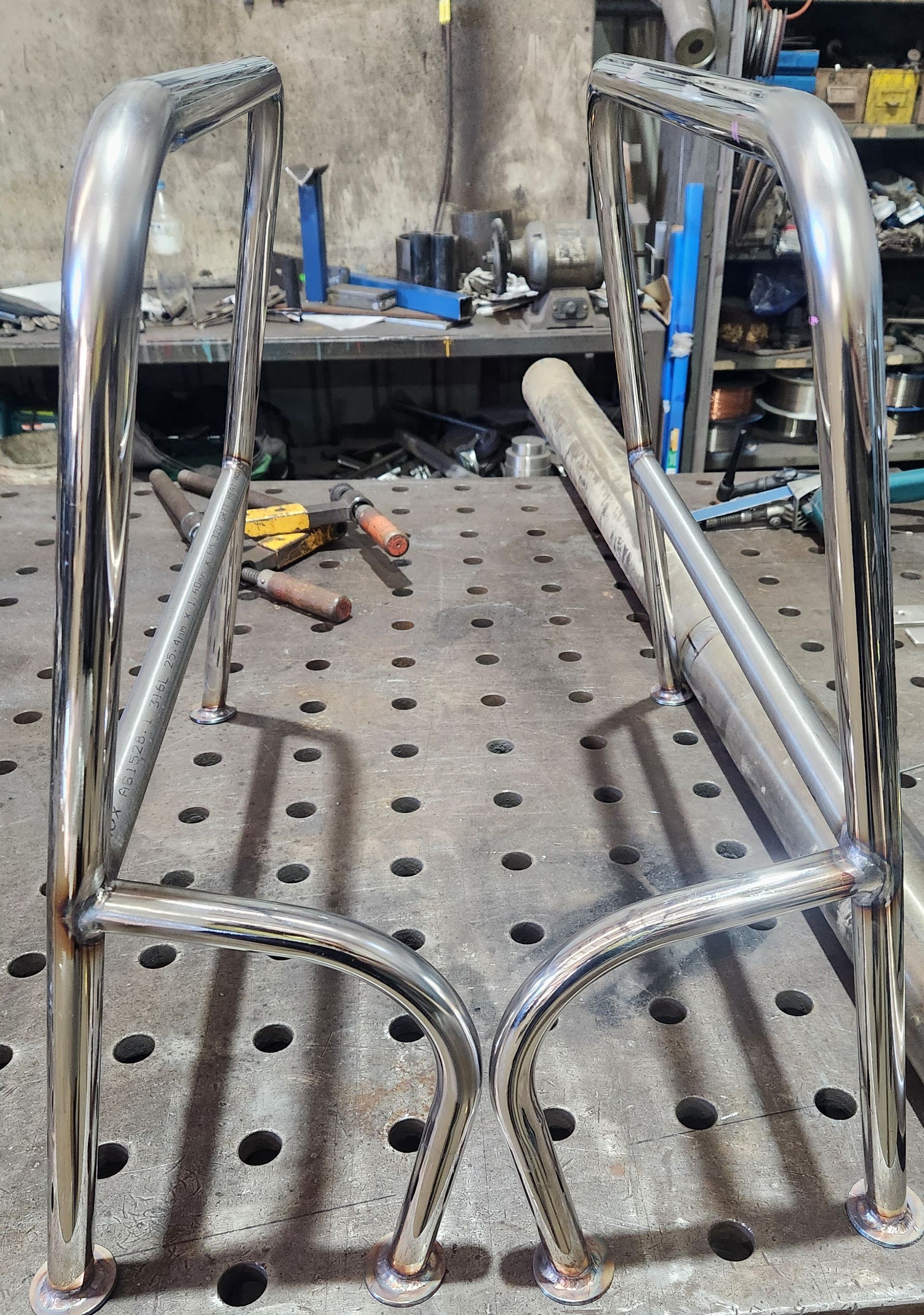 A stainless steel railing is sitting on top of a metal table.