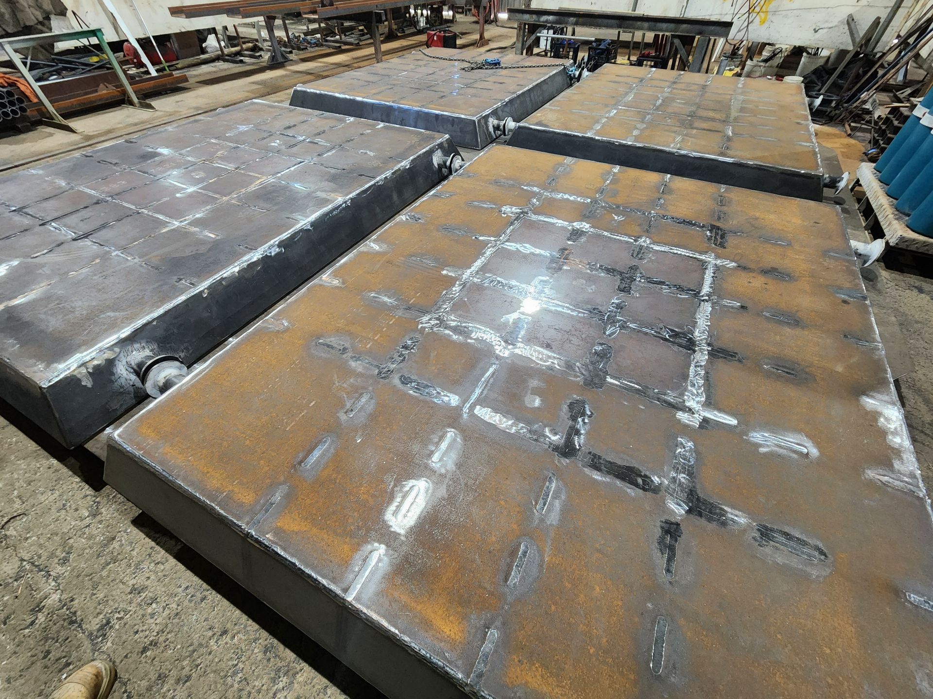 A bunch of metal plates are sitting on top of each other on the ground.