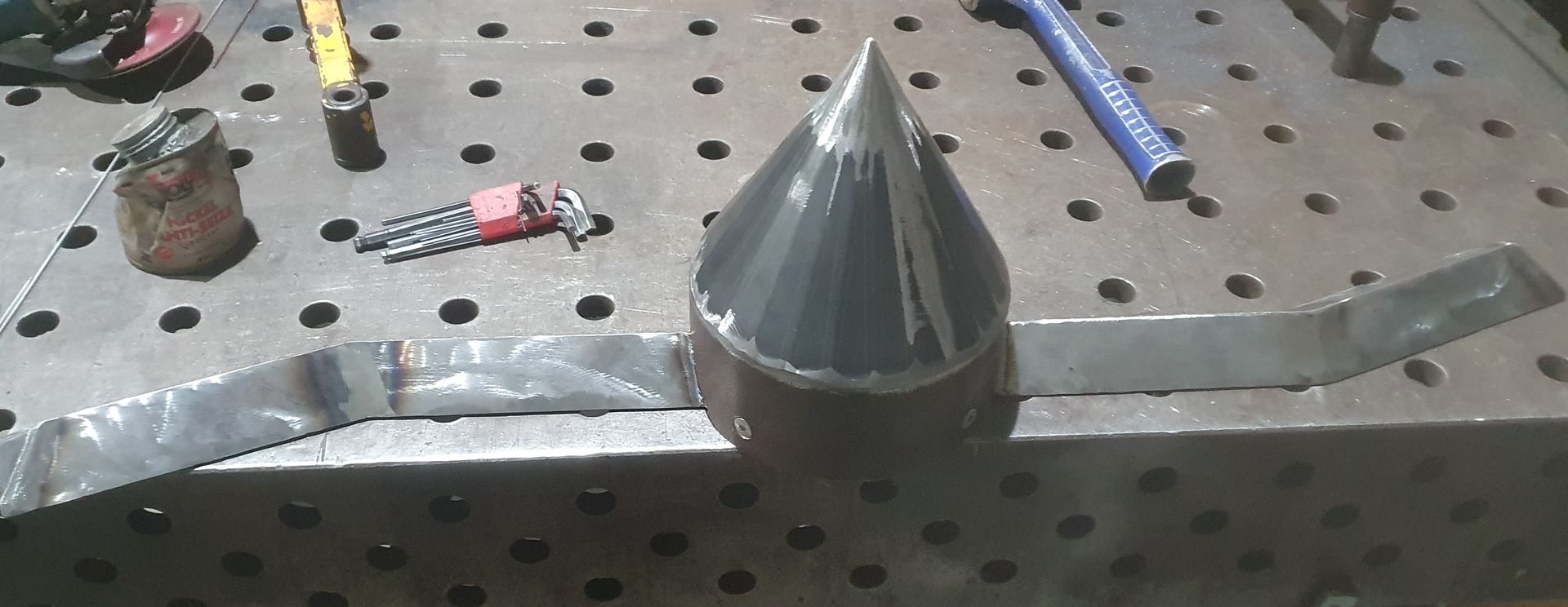 A metal cone is sitting on top of a metal table.