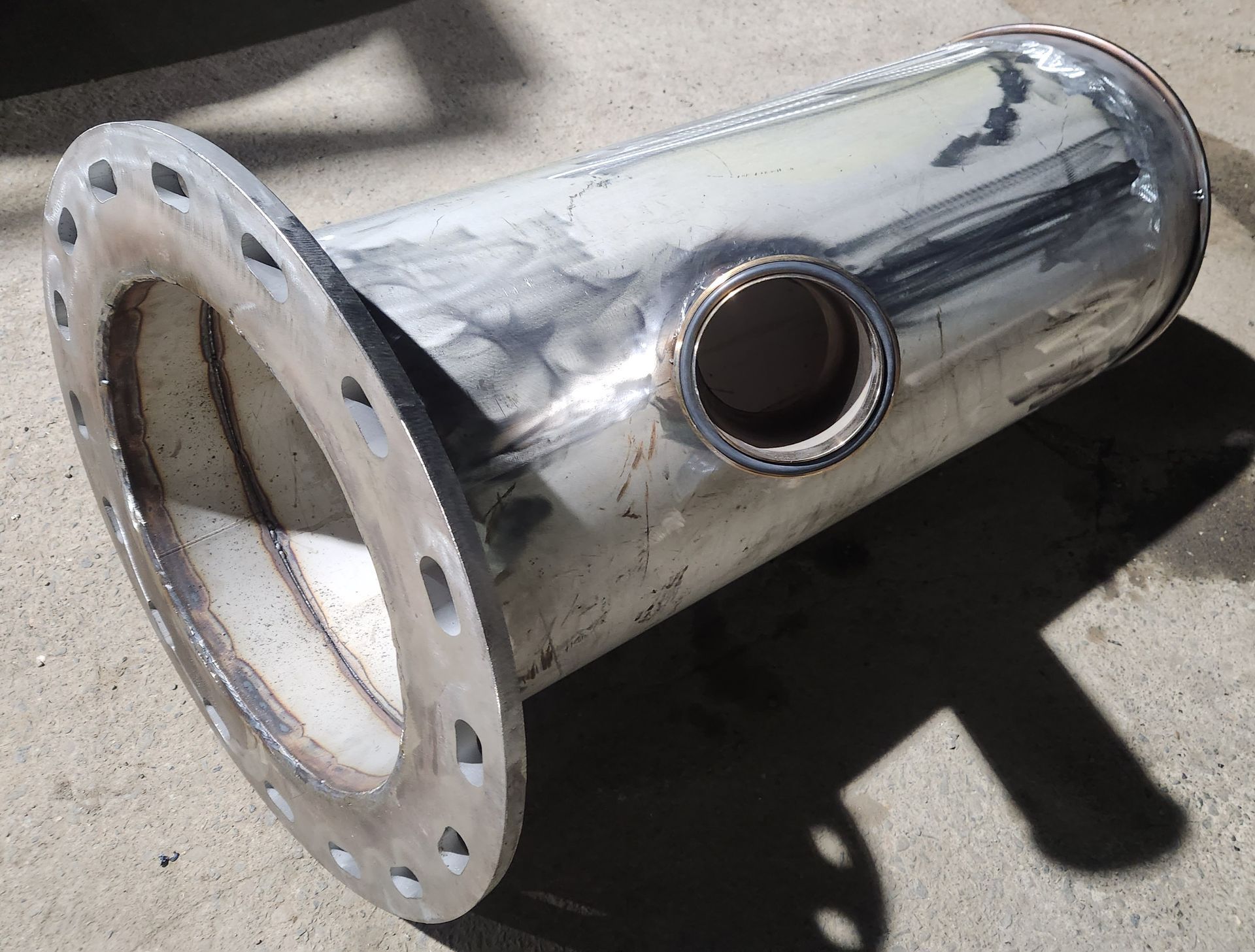 A stainless steel pipe with a hole in the middle