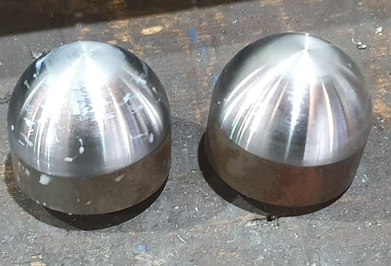 Two stainless steel spheres are sitting on a table.