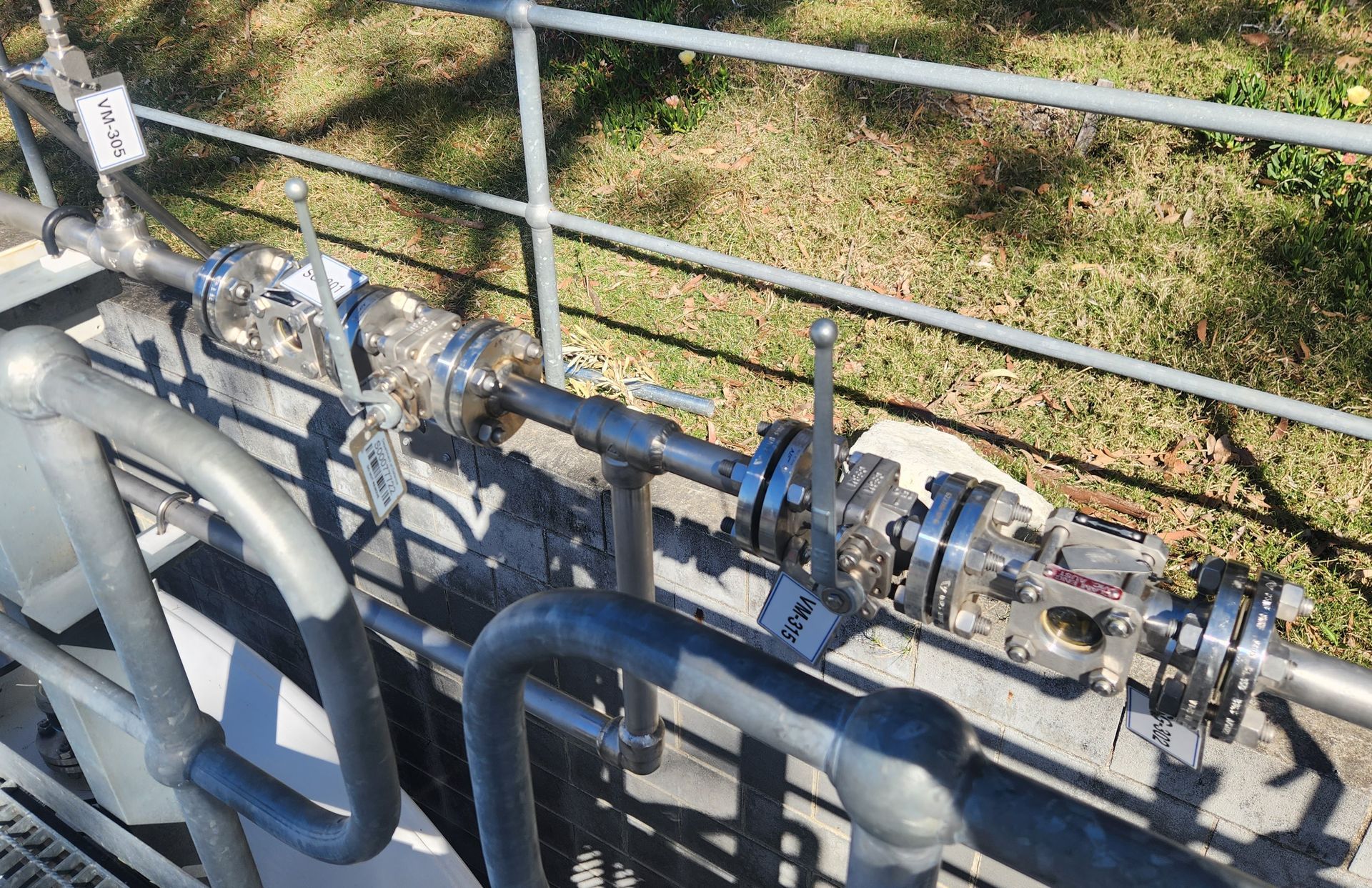 A bunch of pipes are connected to a metal railing.