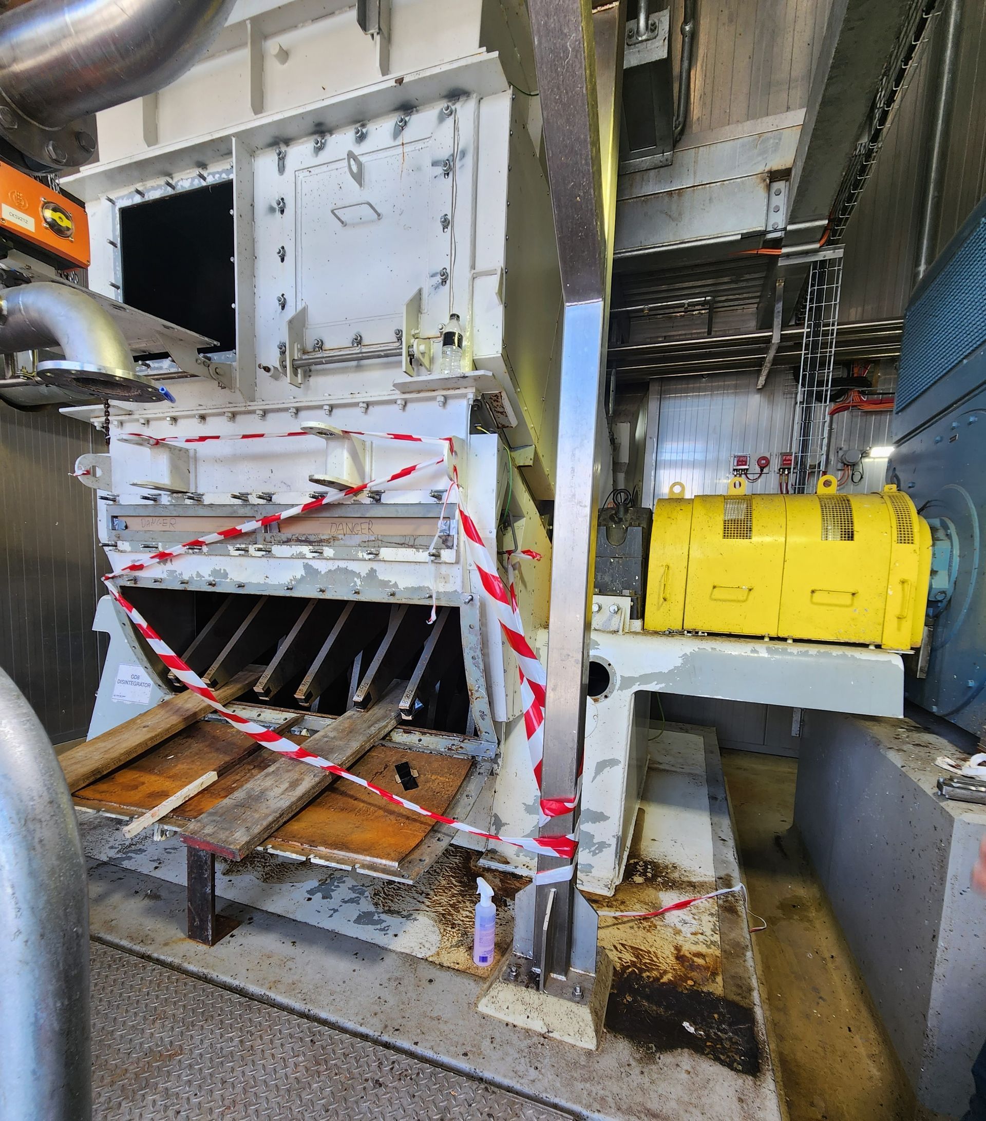 A machine with a yellow motor and red and white tape around it