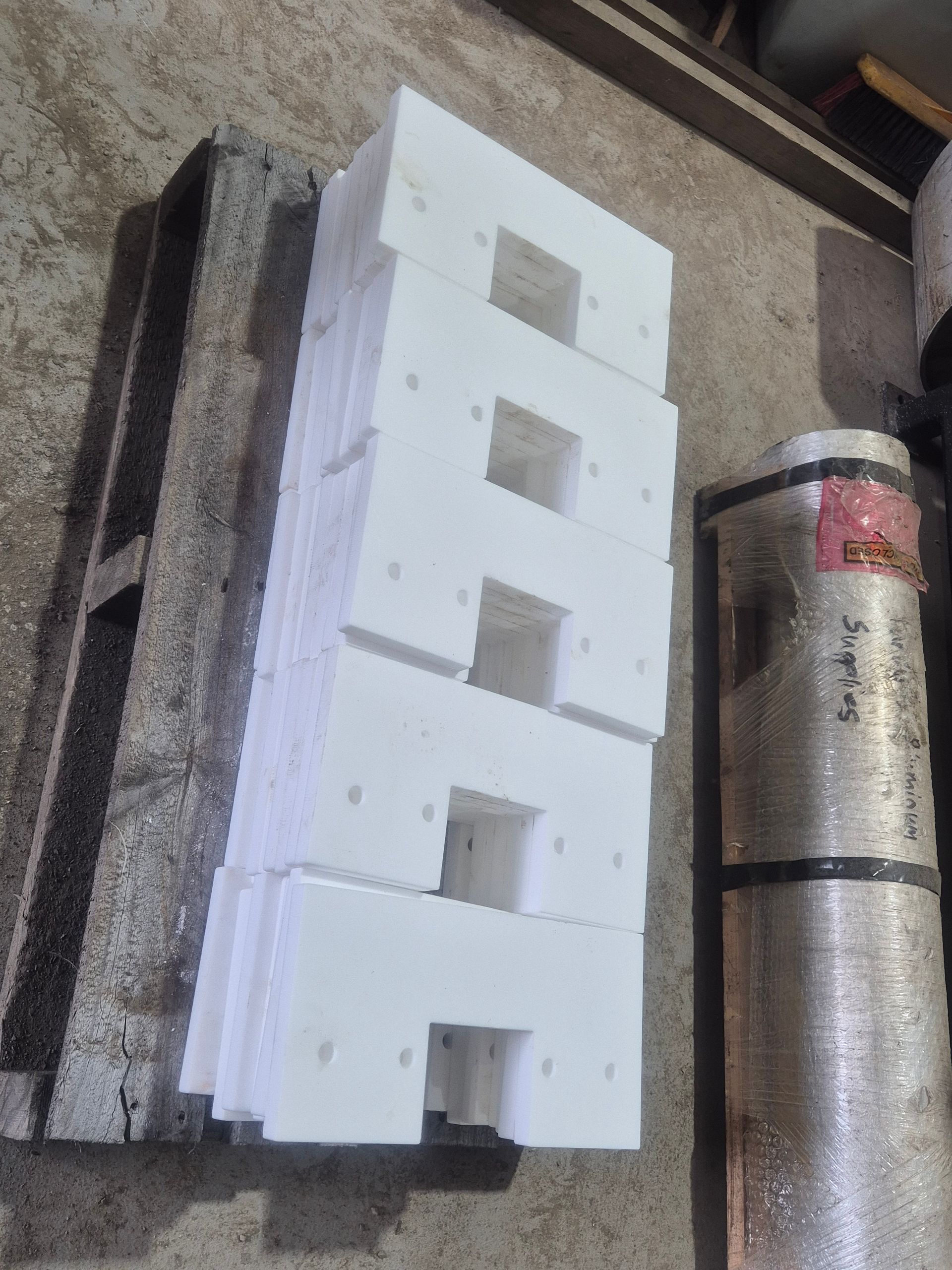 A stack of white blocks sitting on top of a wooden pallet.