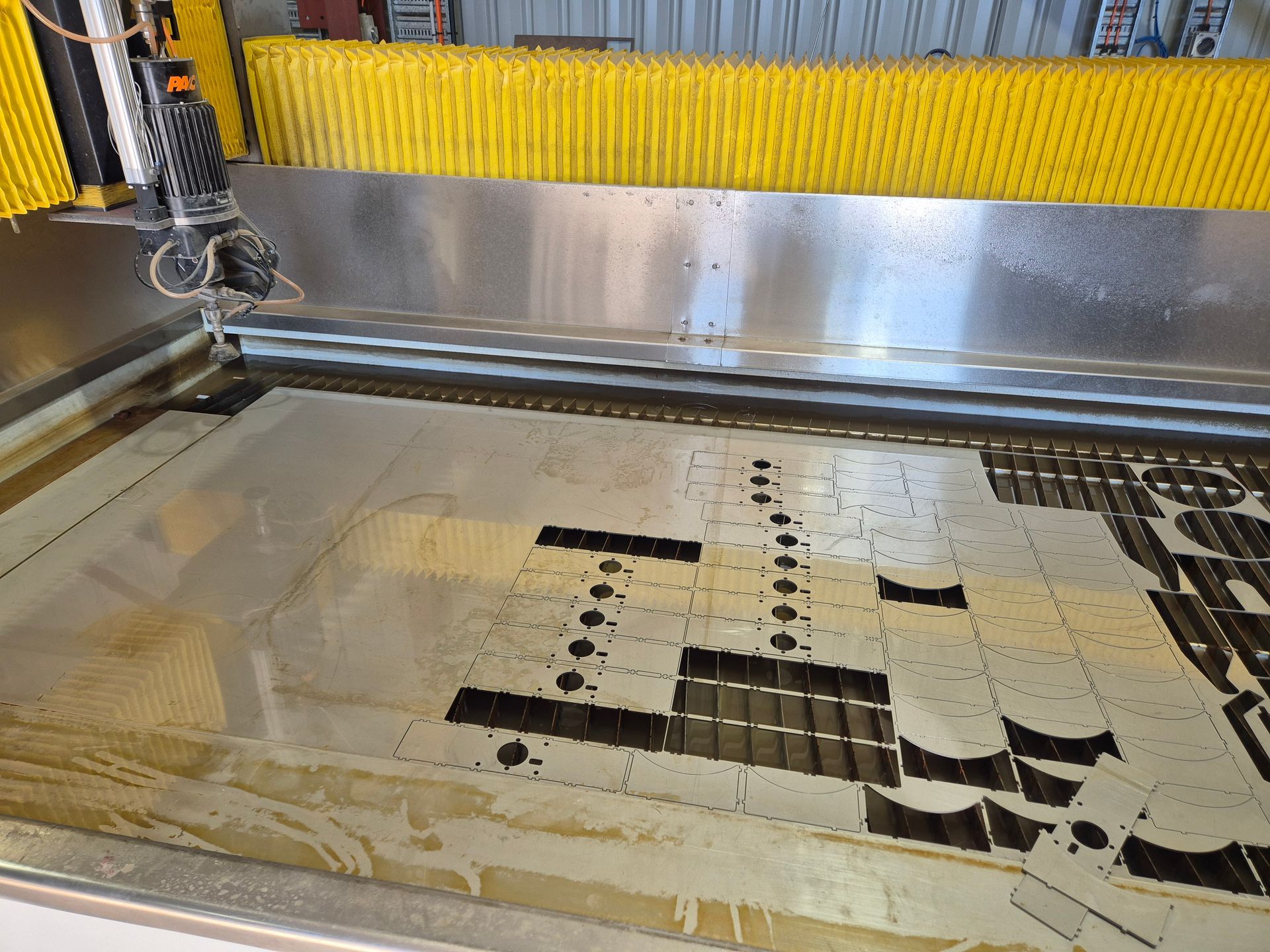 A machine is cutting a piece of metal with water.