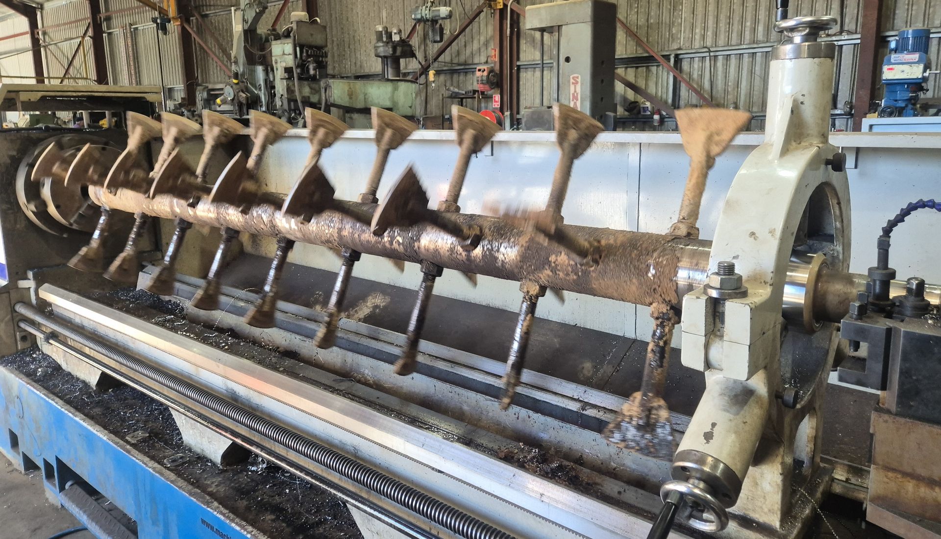 A large lathe is sitting in a factory.