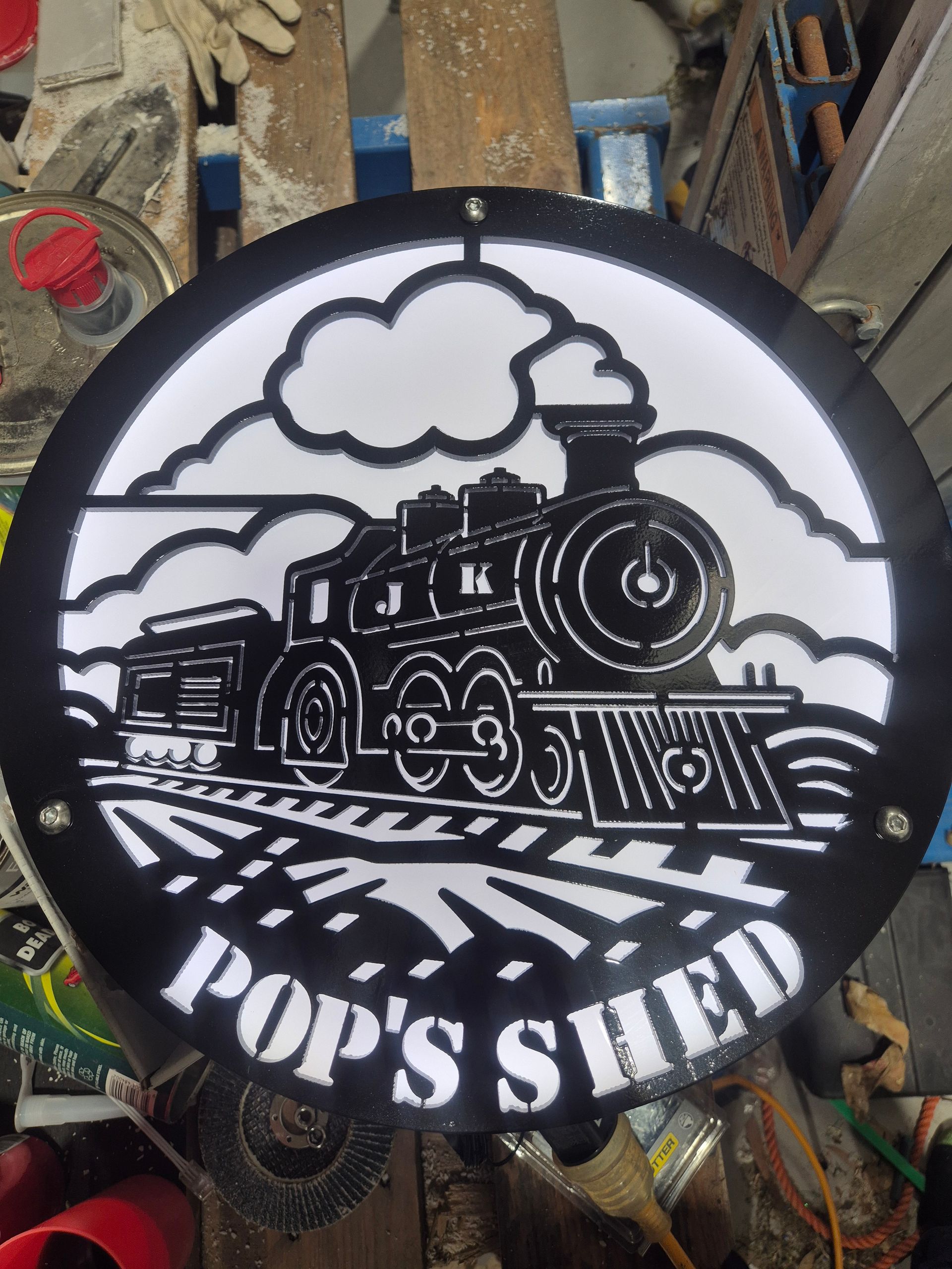 A sign that says pop 's shed with a train on it
