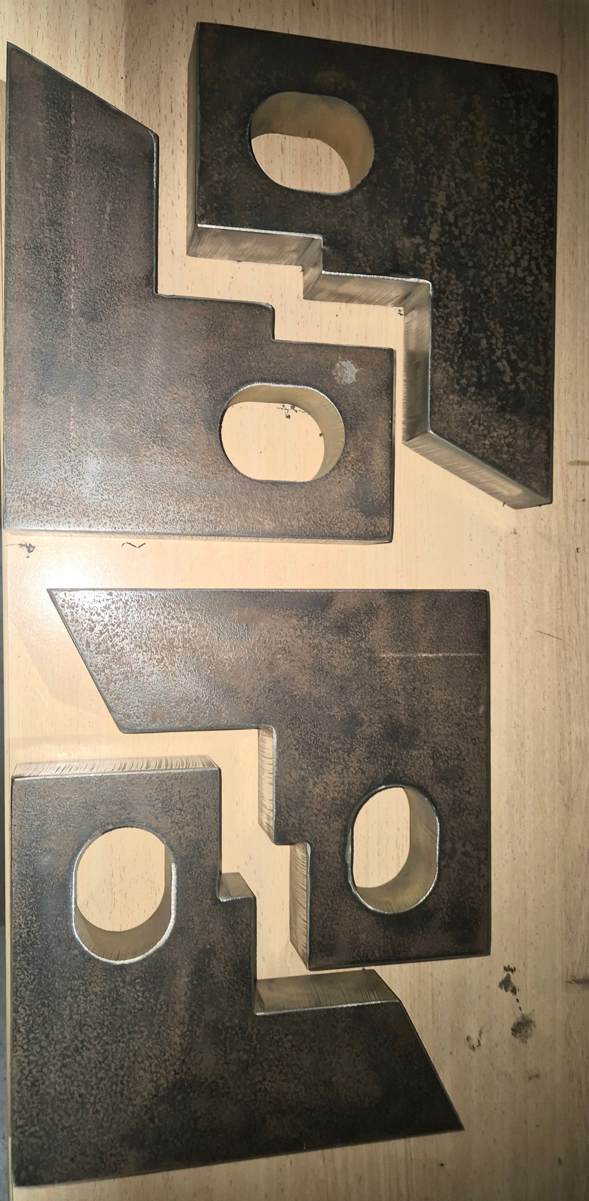 A bunch of metal pieces with holes in them are sitting on a table.