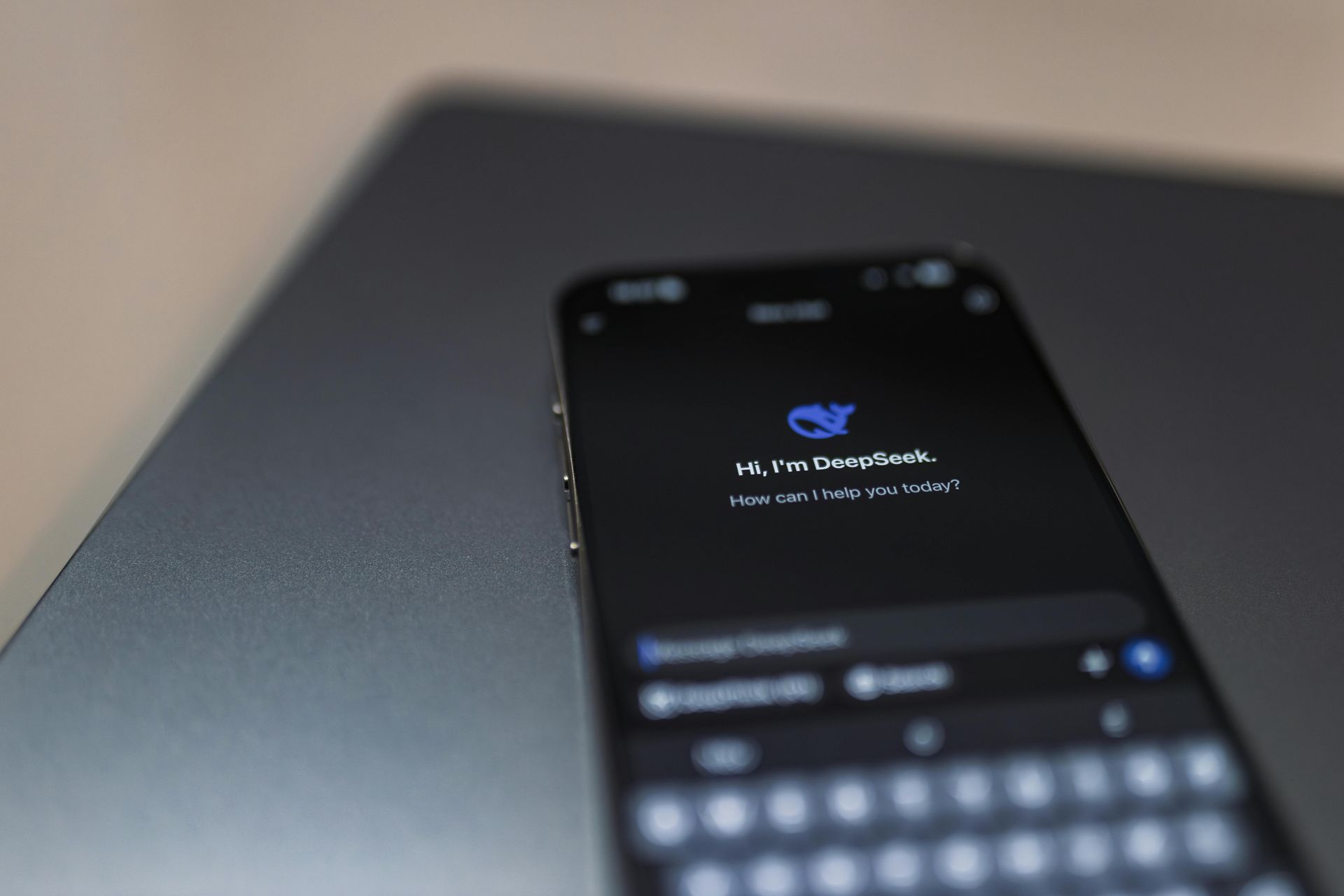 Smartphone on laptop displays a text message on a dark screen.