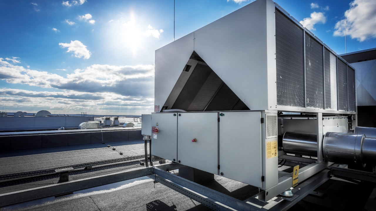 A large air conditioner is sitting on top of a building.