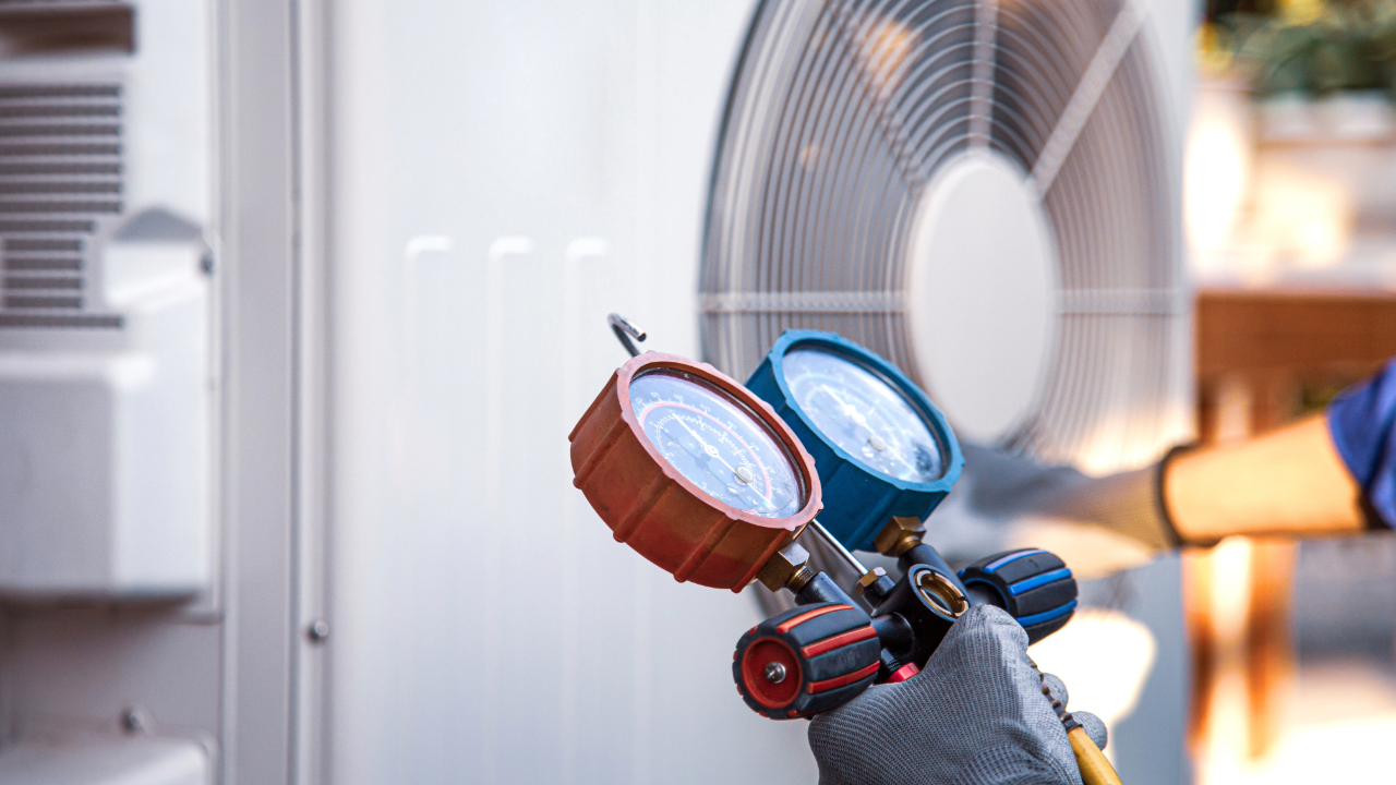 A person is holding a gauge in front of a fan.