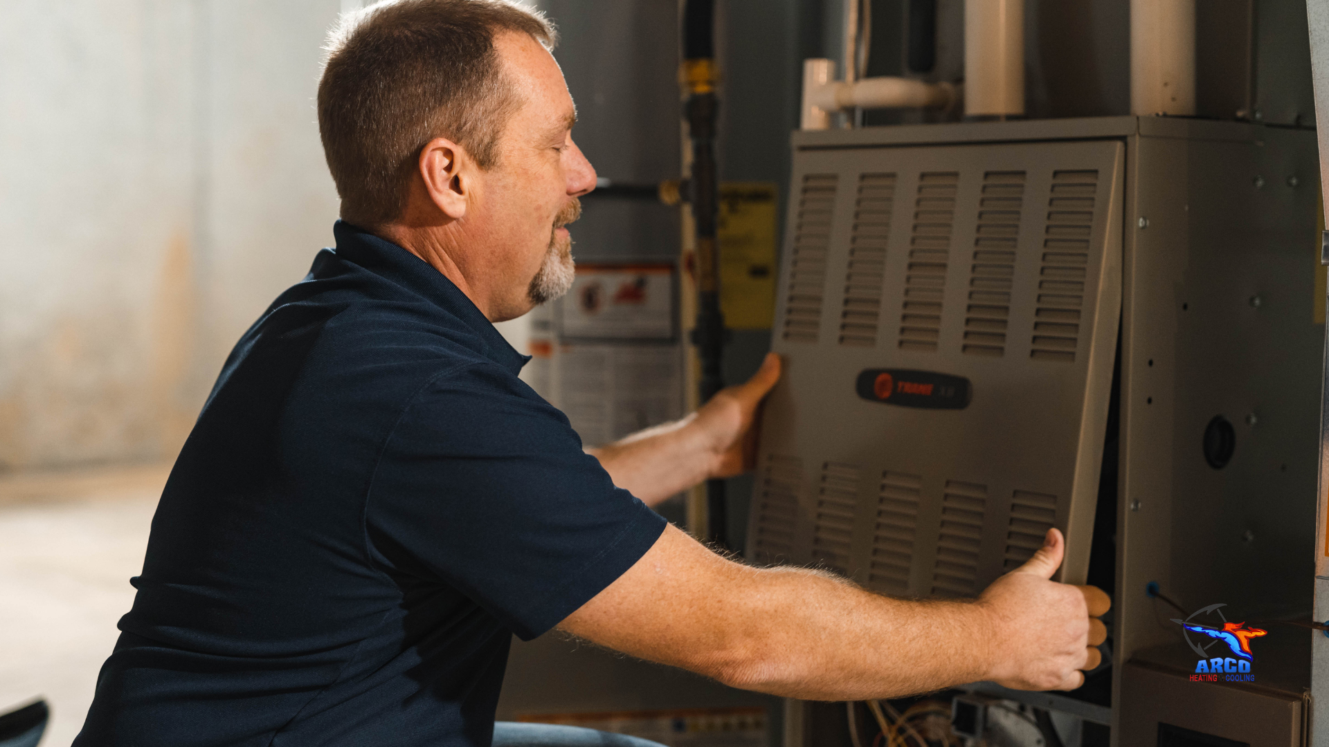 A man is working on a furnace and giving a thumbs up.