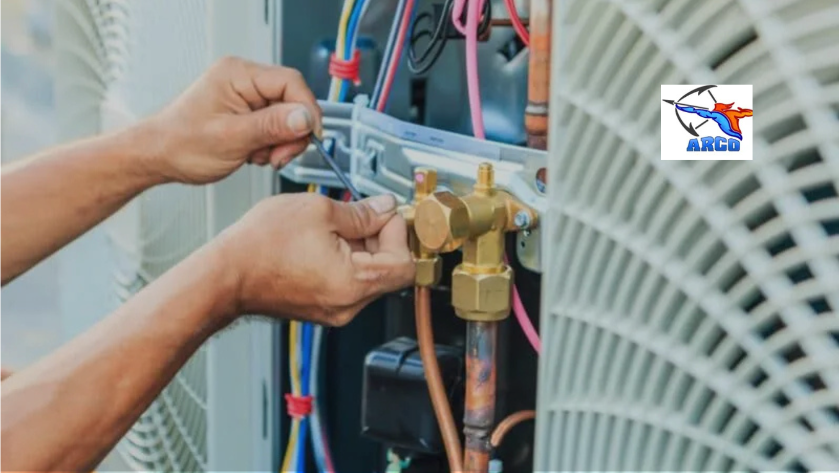 Person's hands working on HVAC system's valve with wiring visible, likely for repair. Close-up with an ARCO logo.