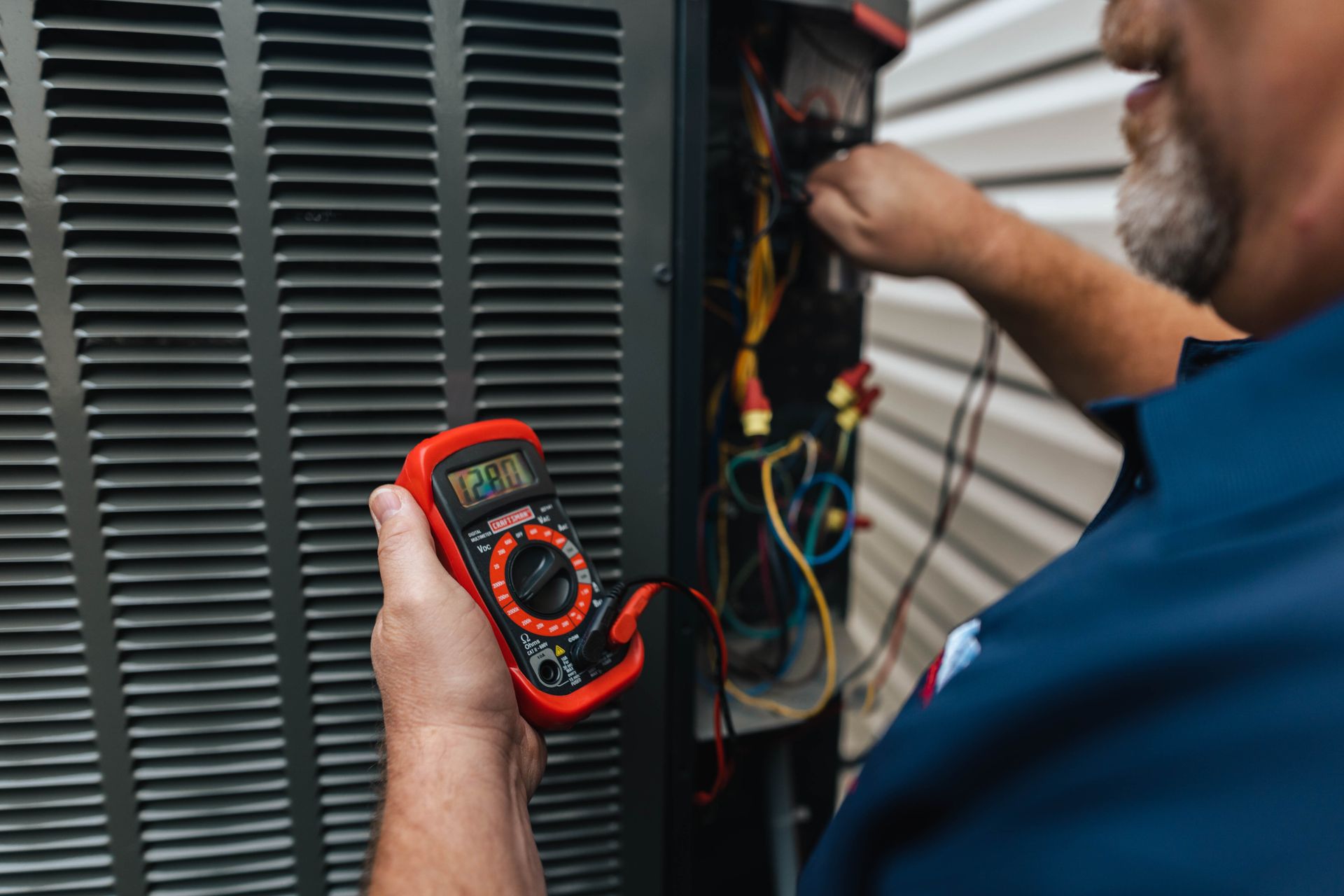 A man test voltage on an hvac unit