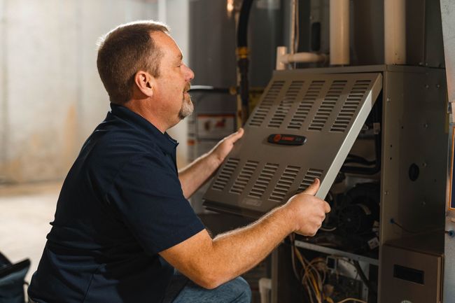 A man putting a cover on a furnace
