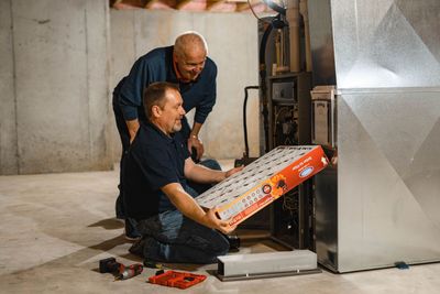 A man installing a furnace filter