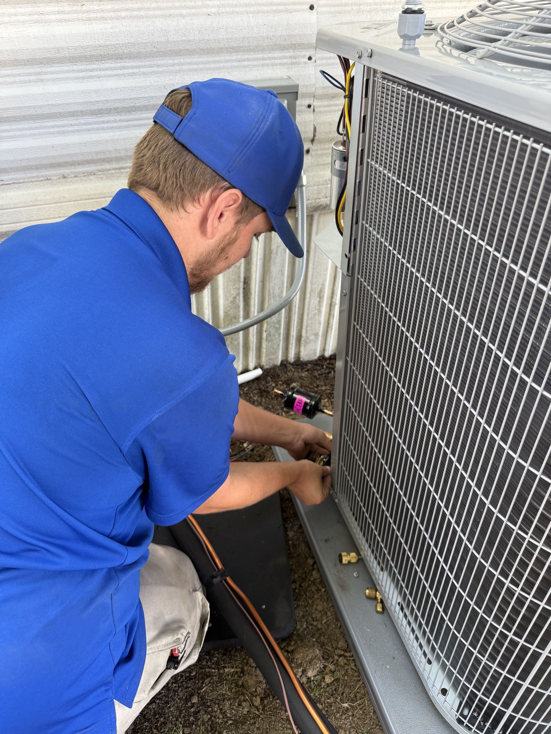 a man working on an outside air conditioner